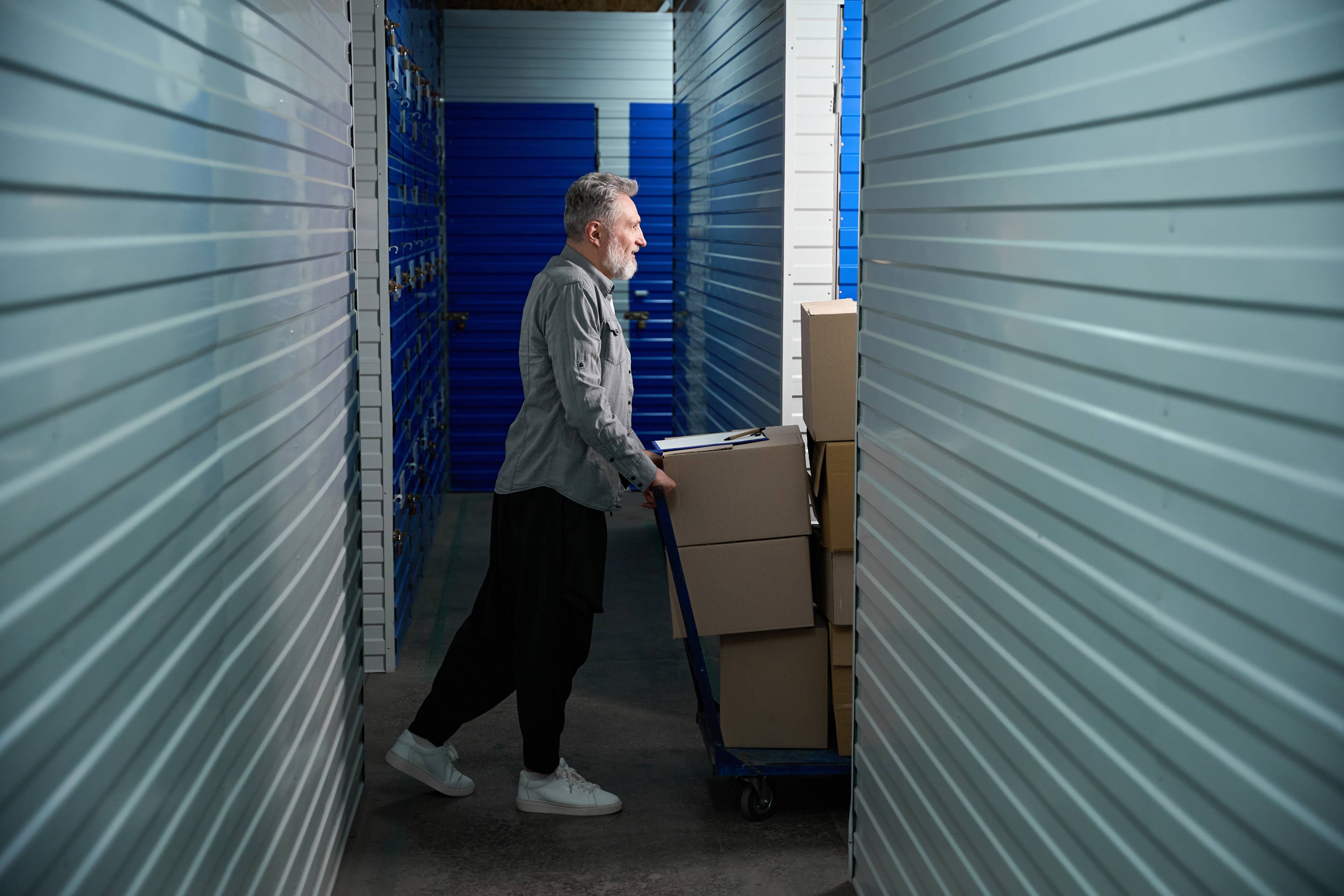 Man moving boxes in a self storage unit.