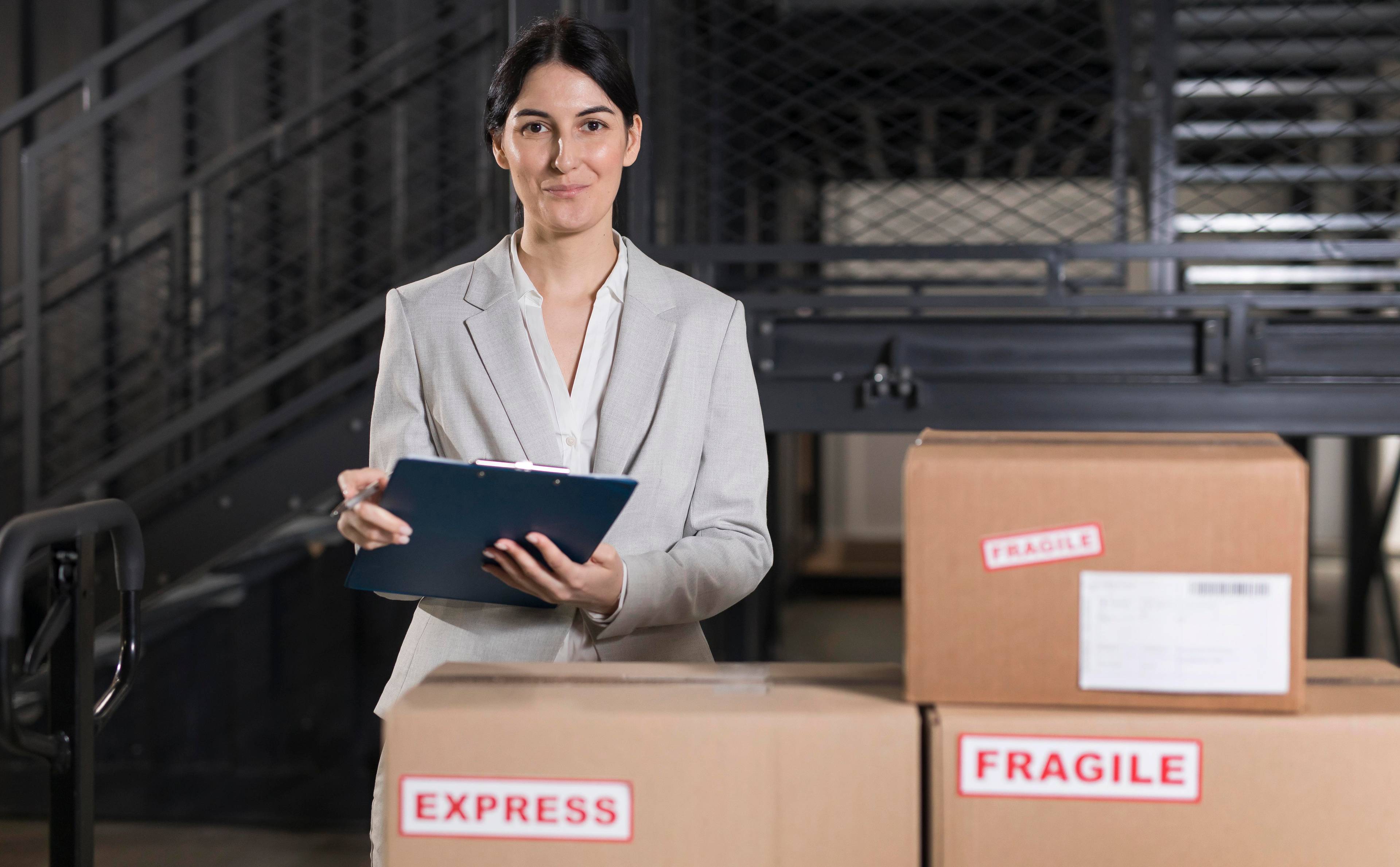 medium shot of woman with clipboard and boxes