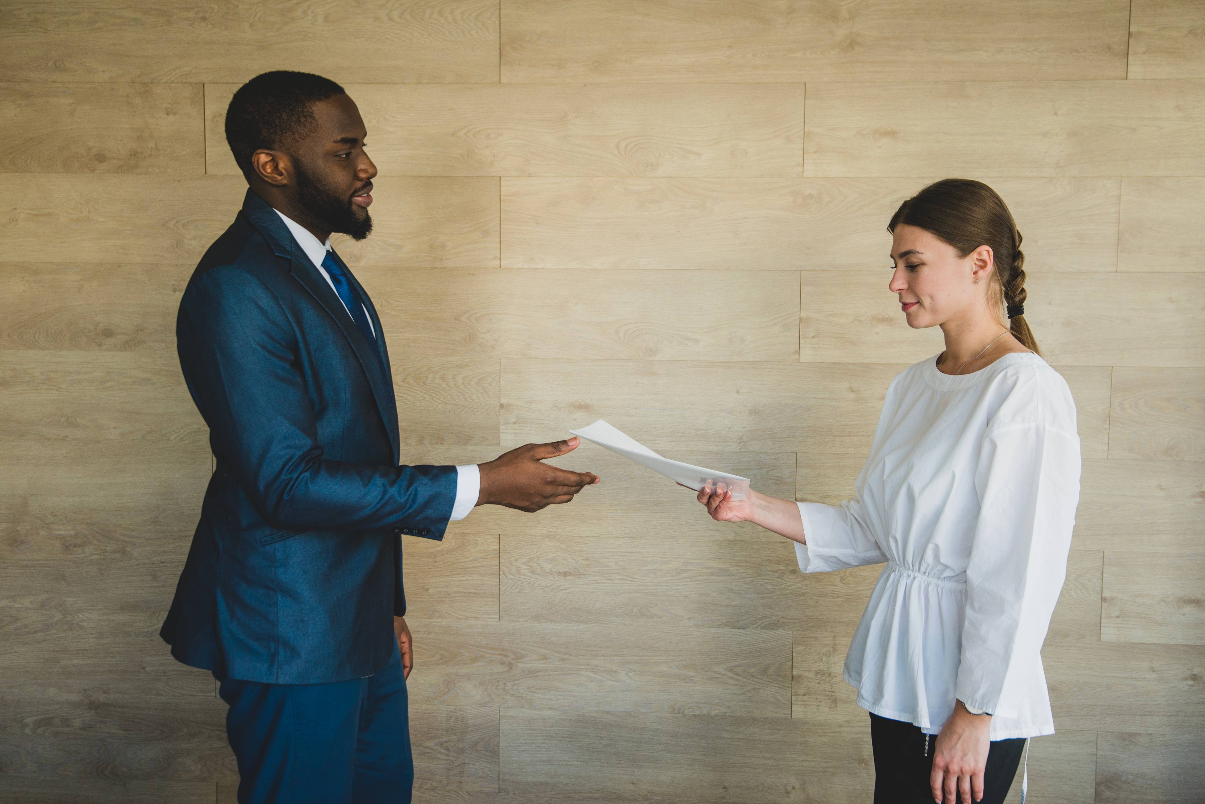 Woman handing papers to businessman