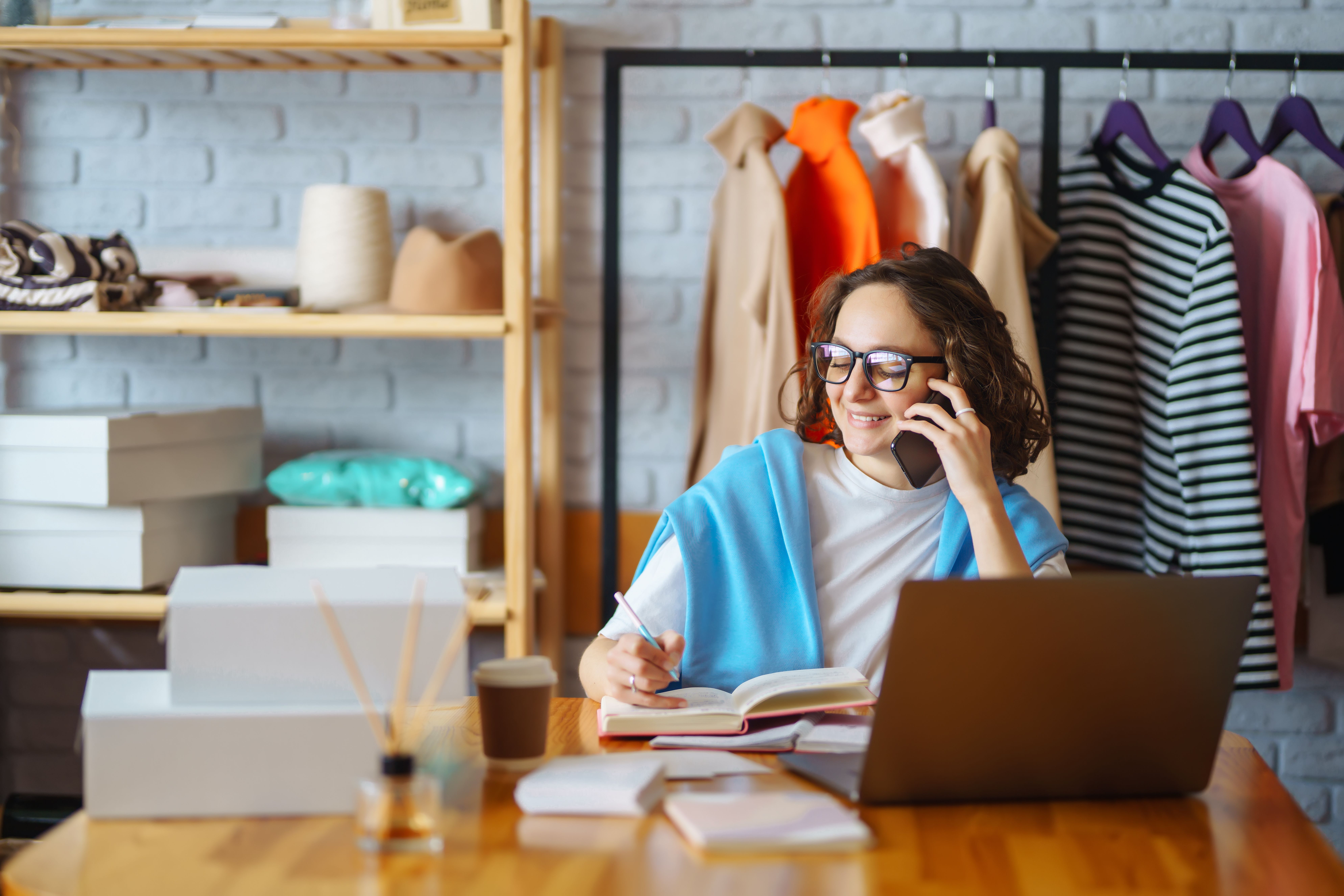 Smiling woman takes notes of orders from with laptop 