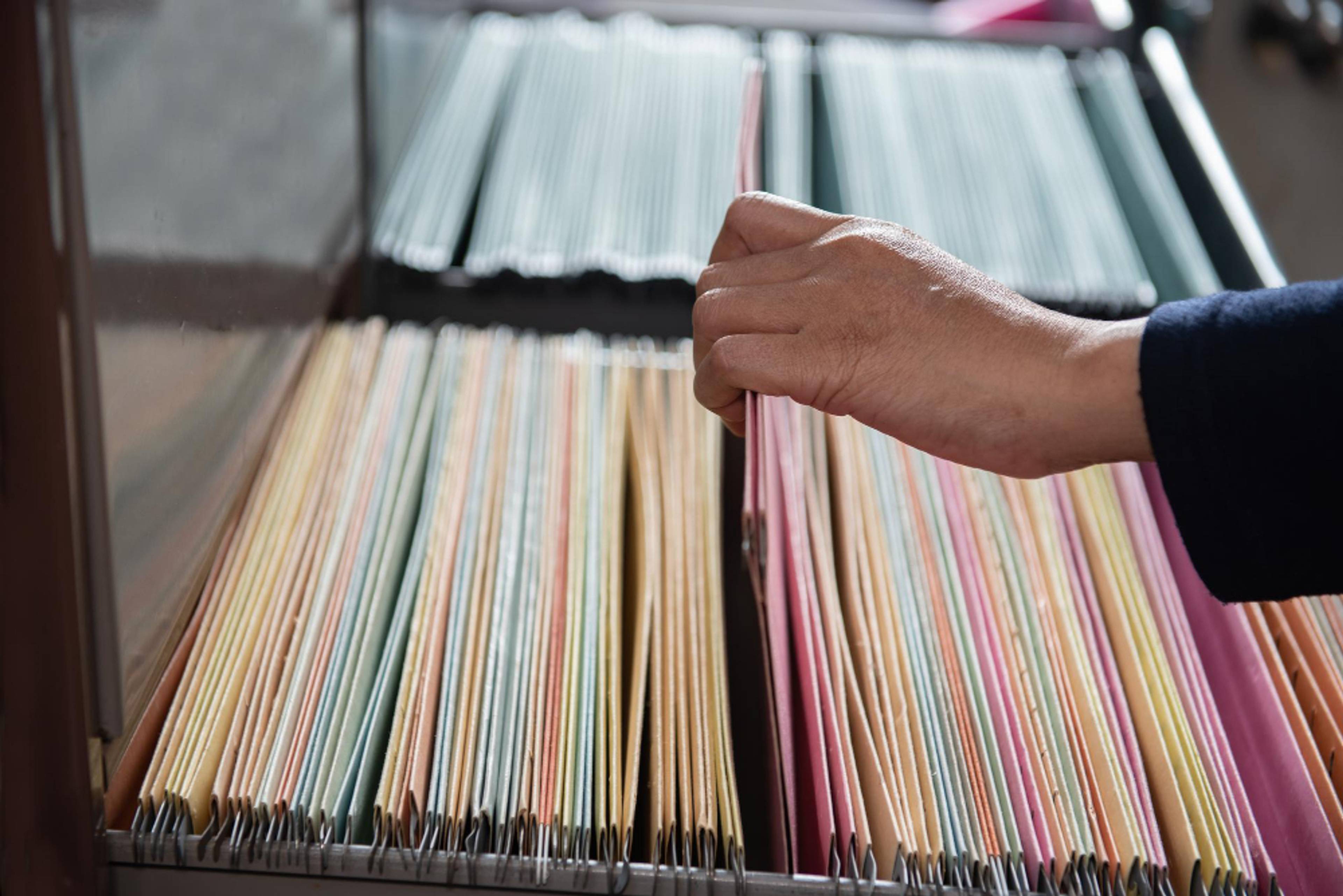 hand picking record out of cabinet of records