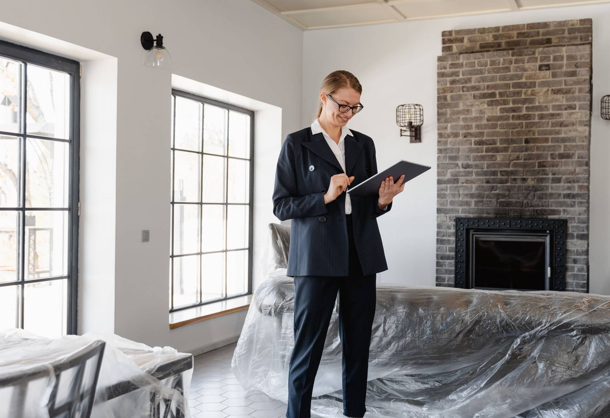 house staged for sale with smiling female estate agent with clipboard