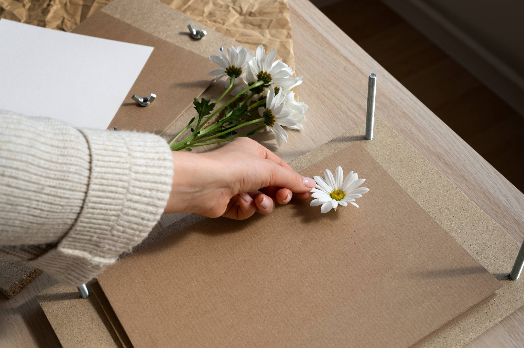 Female placing flowers on cardboard press