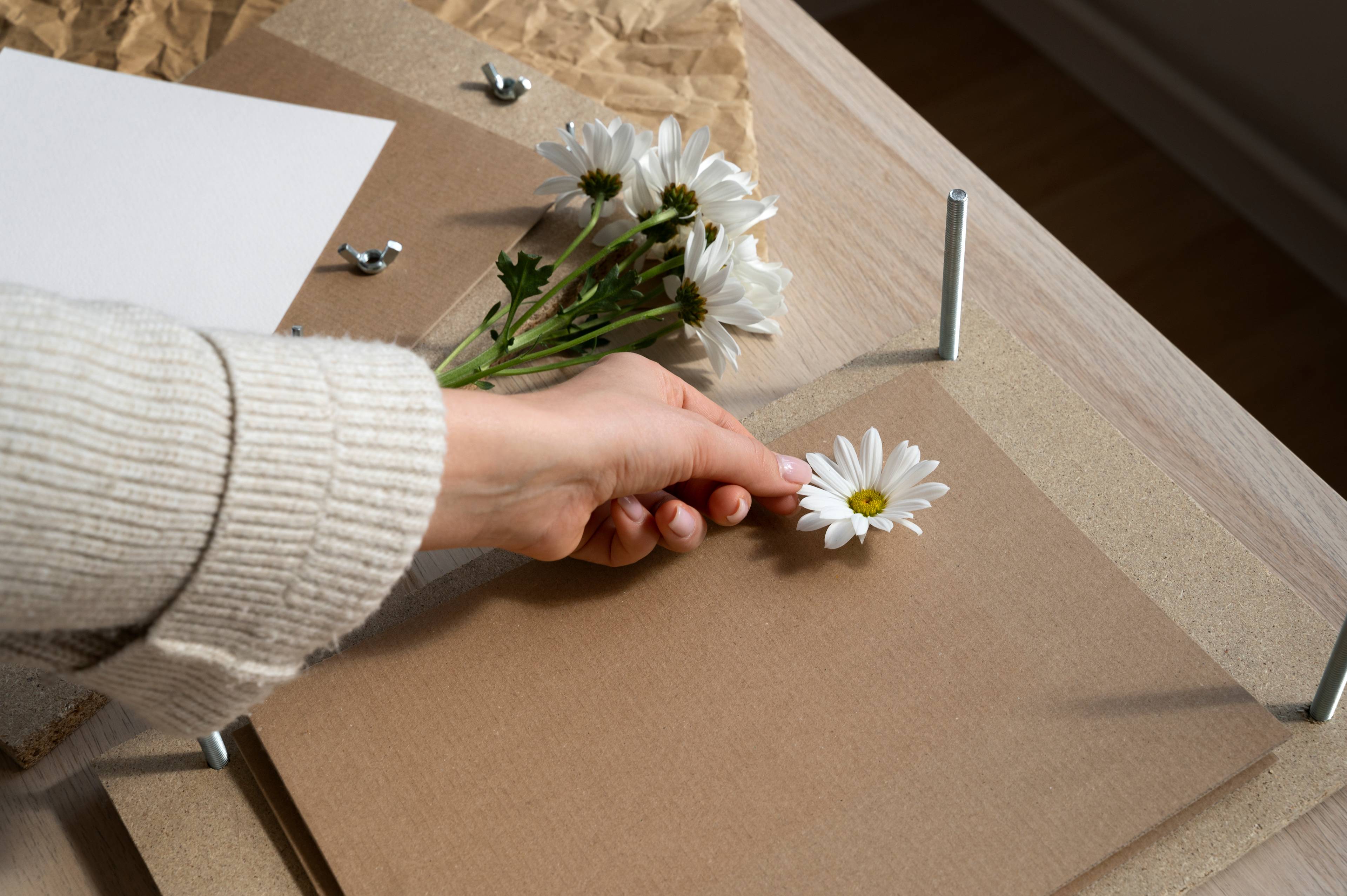 Female placing flowers on cardboard press