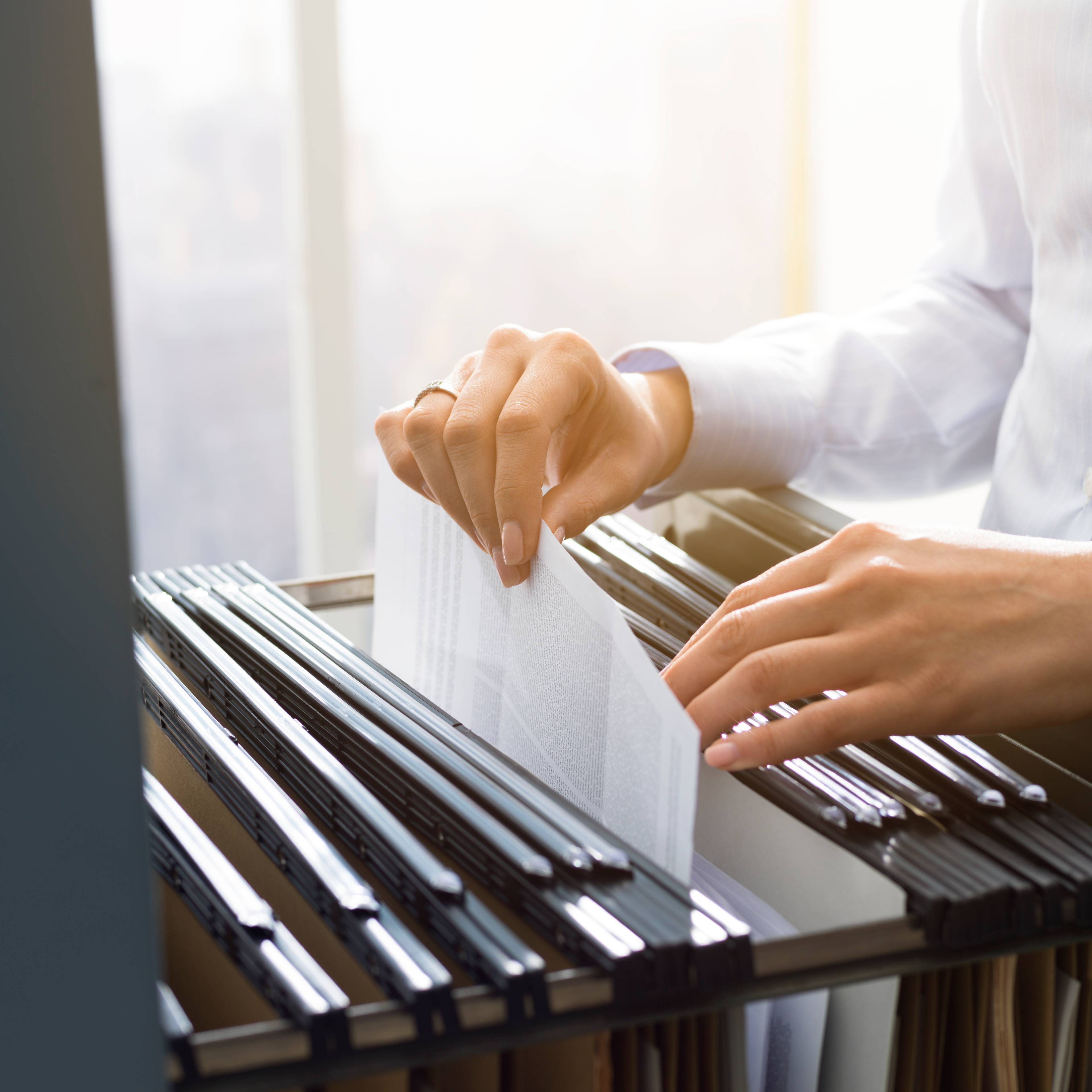 Office clerk searching files in the filing cabinet