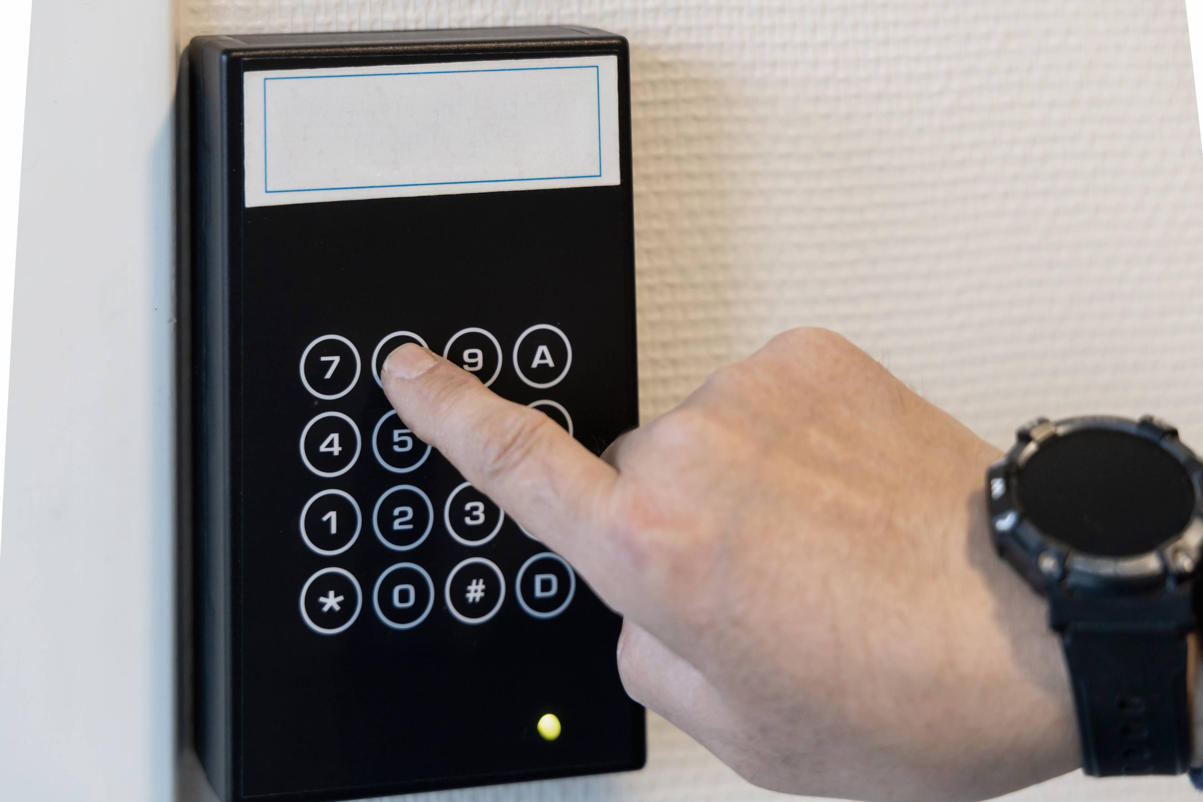 Close up of a man pressing numbers in a keypad lock