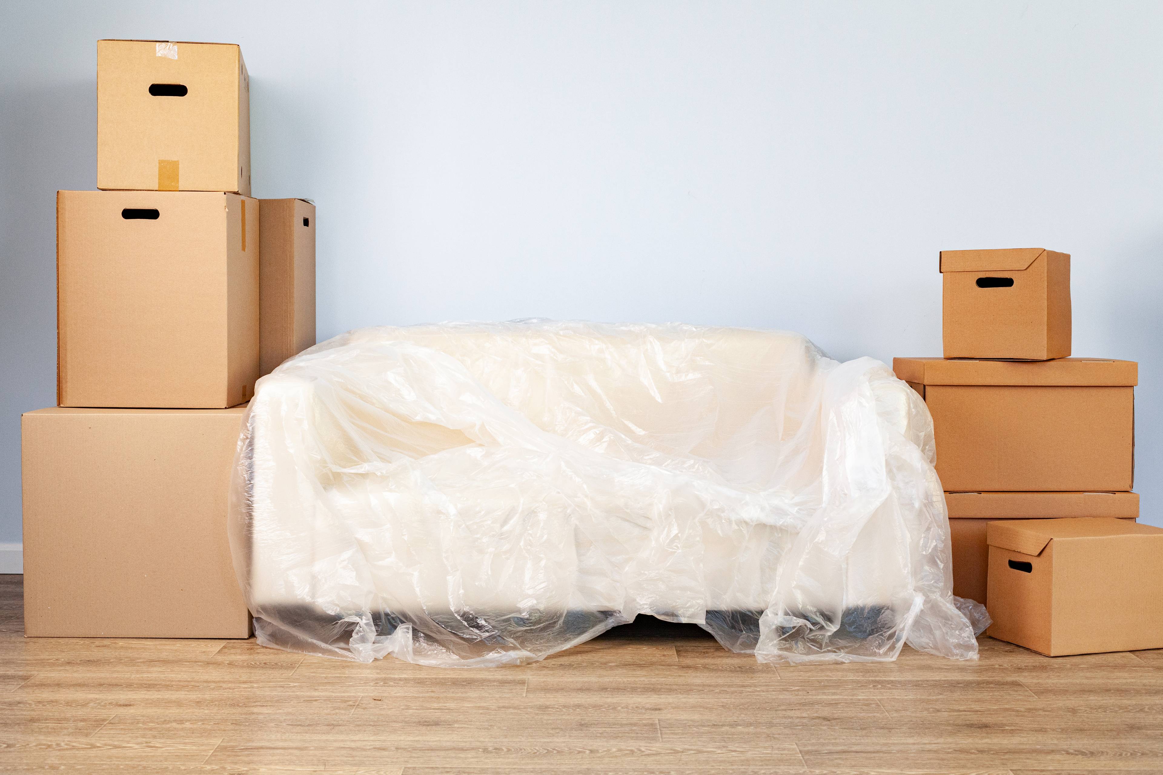 Stack of boxes on both sides of a white couch