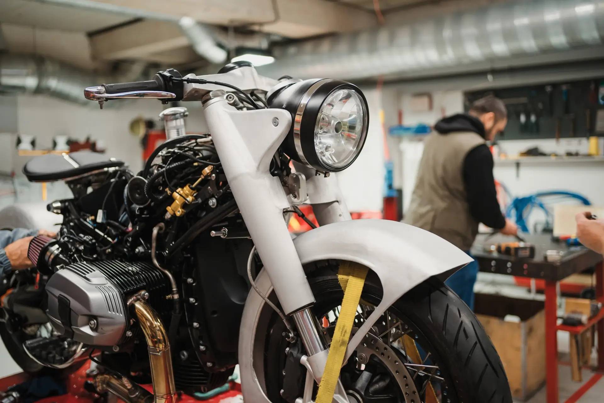 Motorbike in garage with mechanic in background