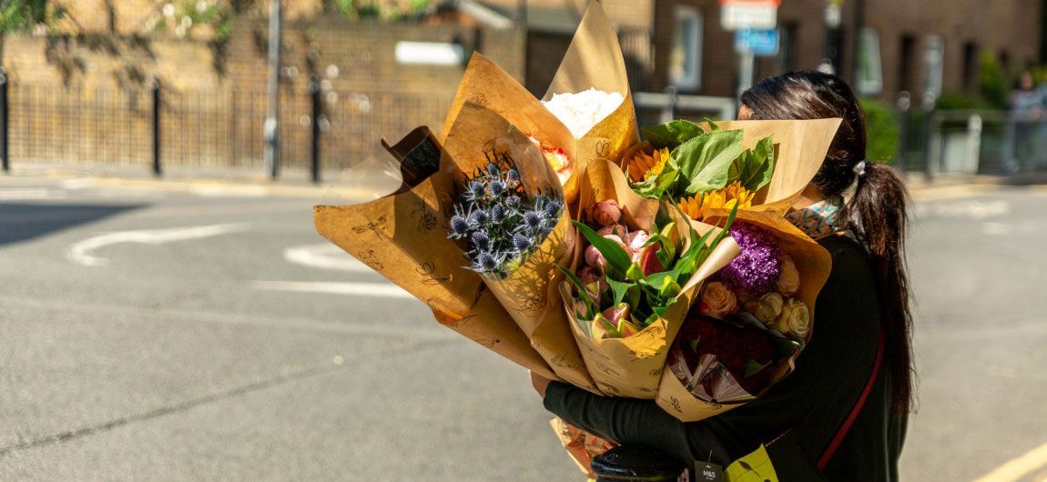 women carrying flowers bought from market