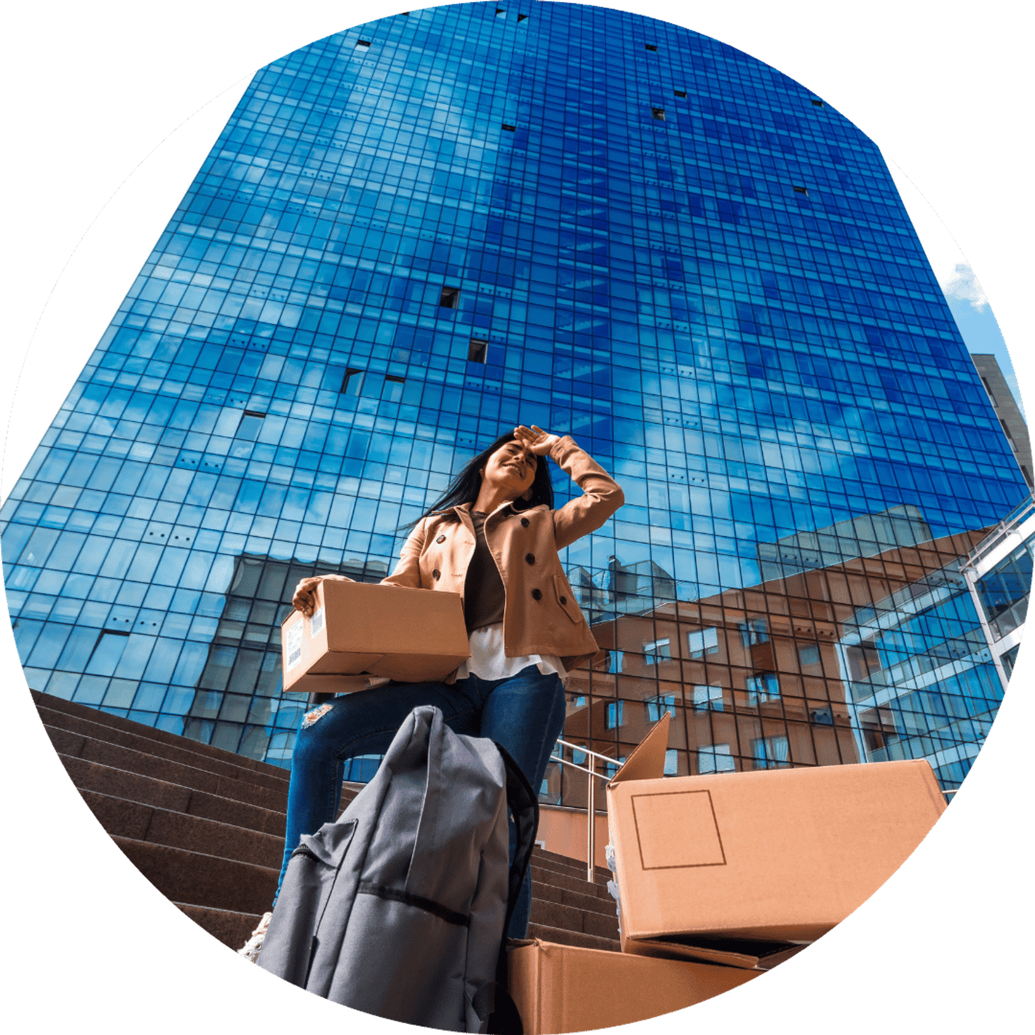 woman with boxes outside tall office building