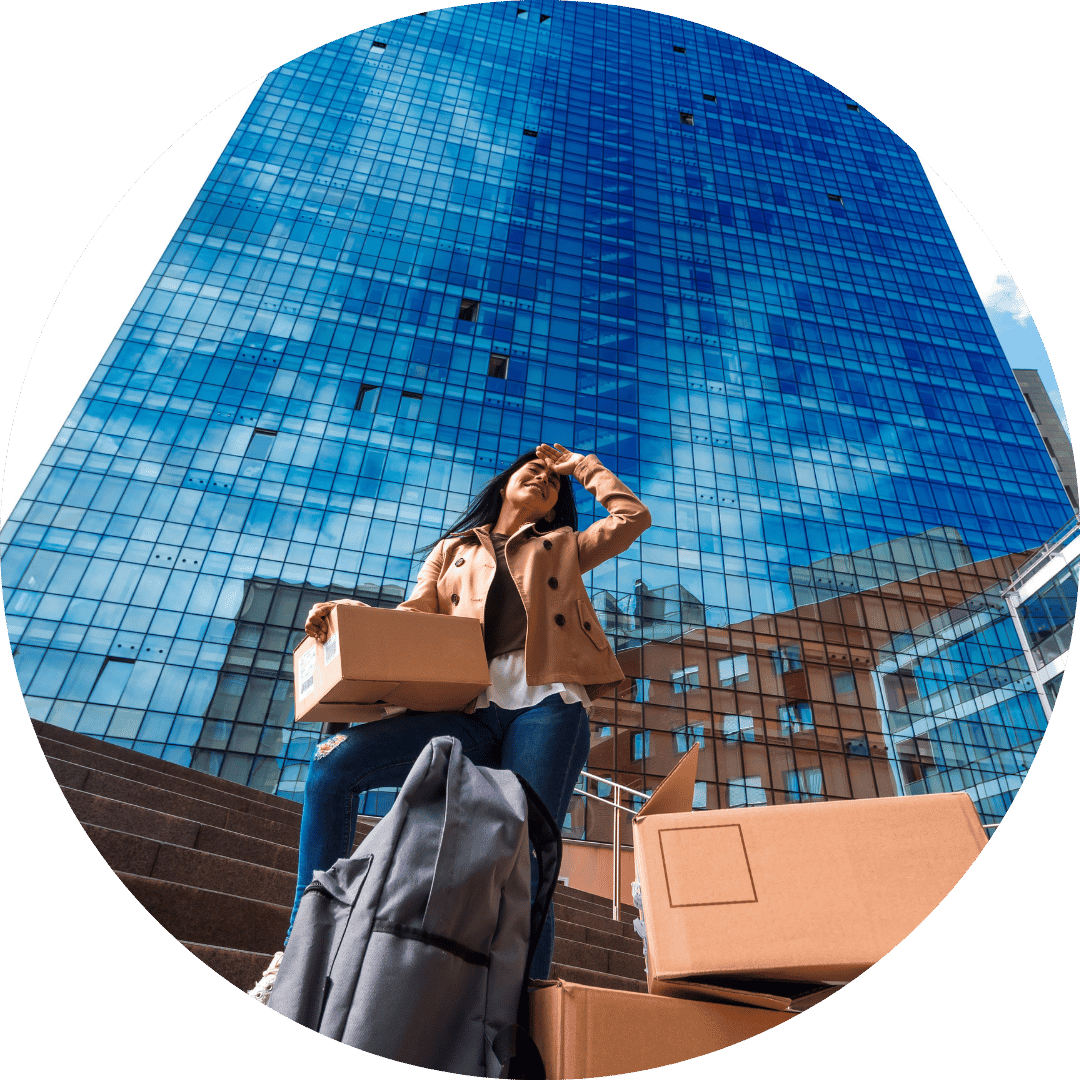 woman with boxes outside tall office building