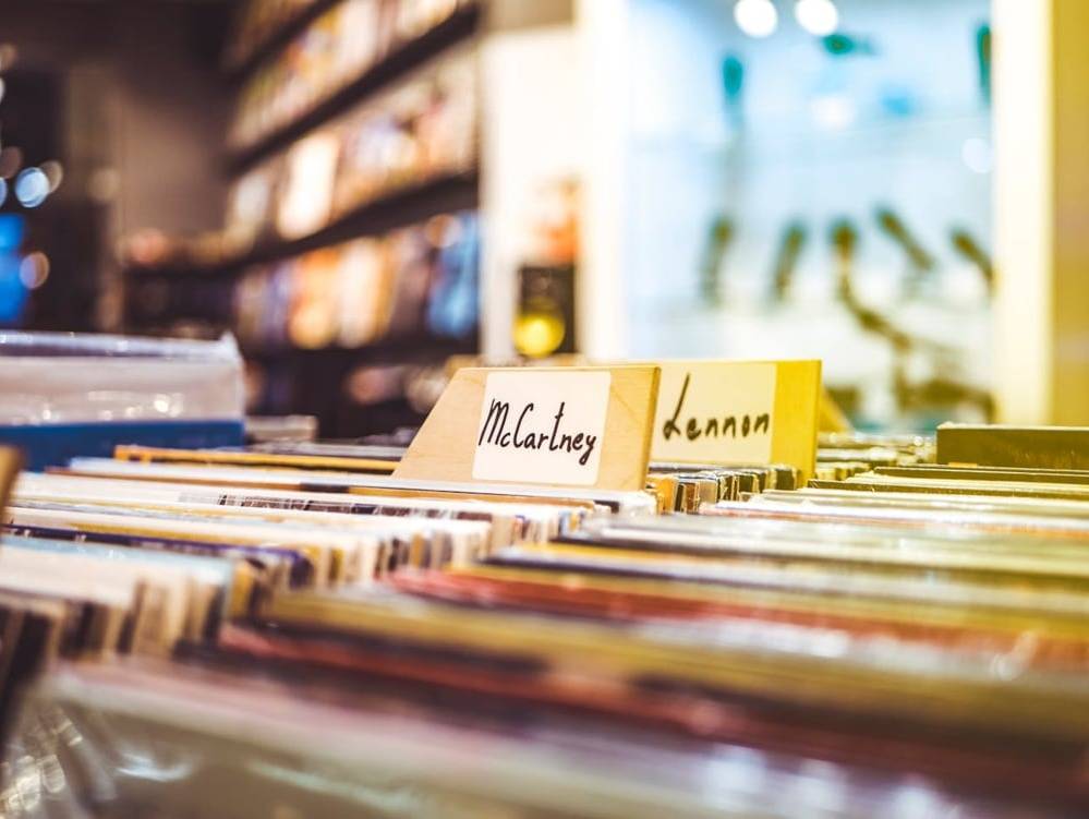 Records in a box in a store, labelled by band
