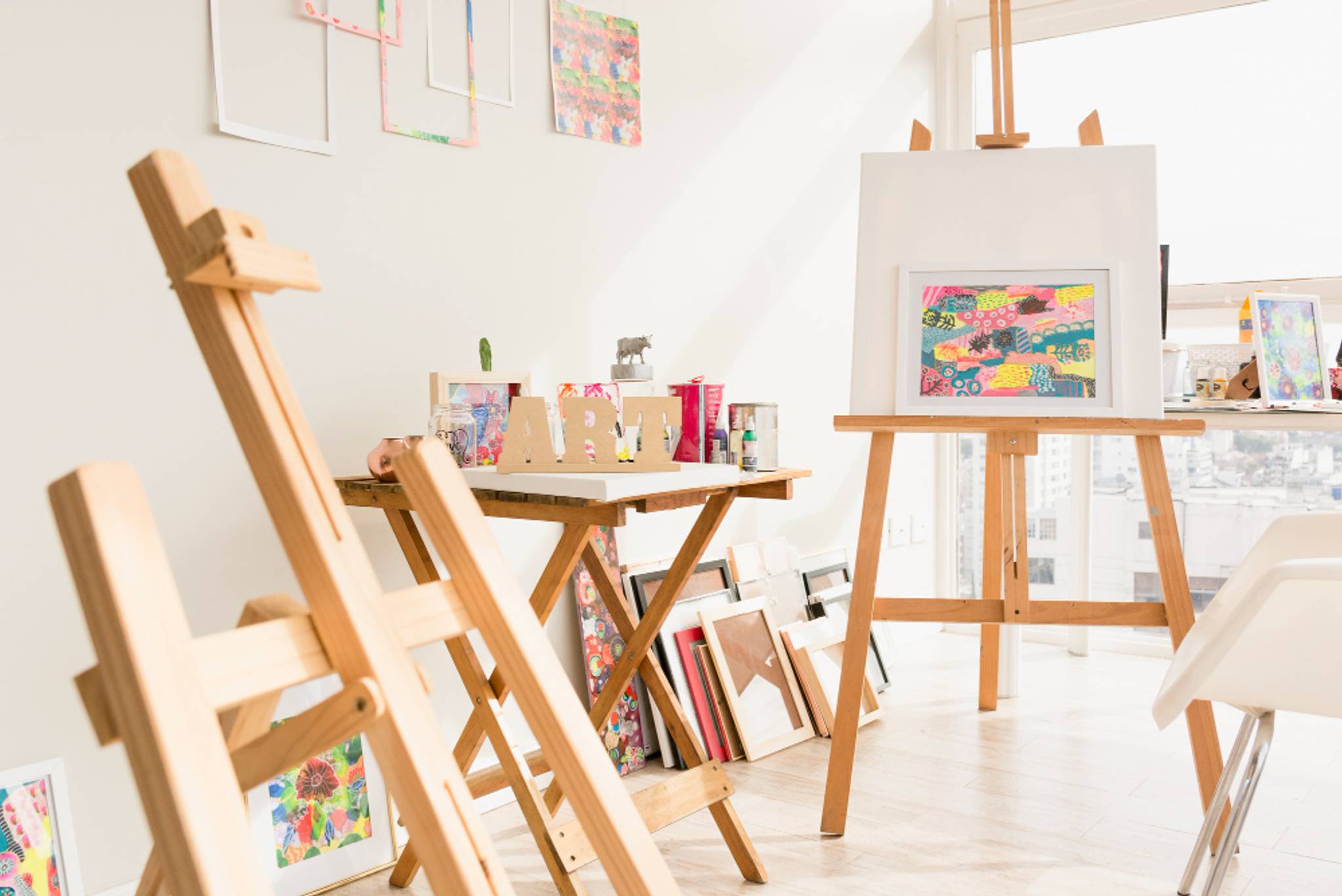 Canvas and painting on easels in a bright room