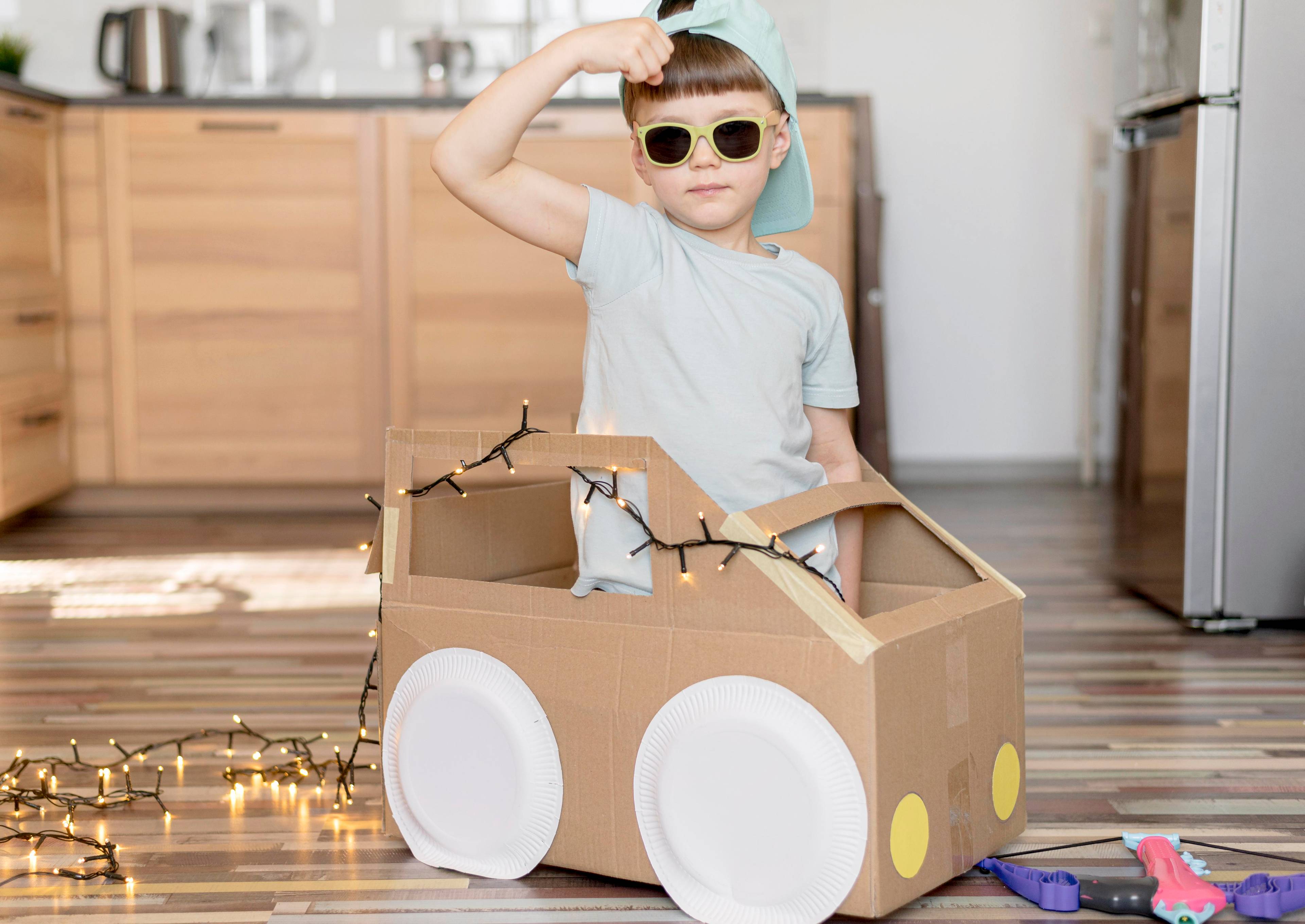 Kid riding a cardboard car