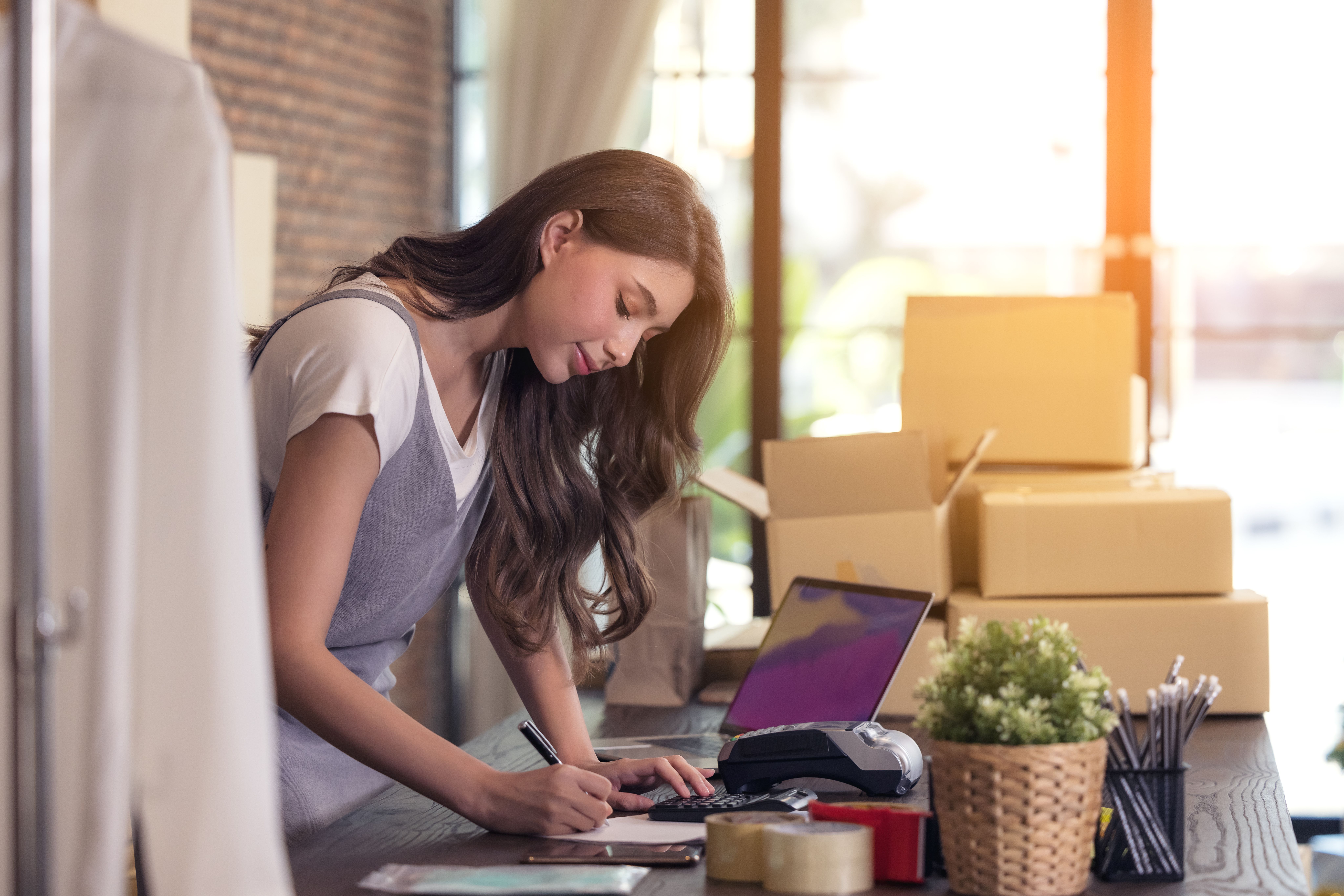 Young woman tailor with laptop is answering emails business woman