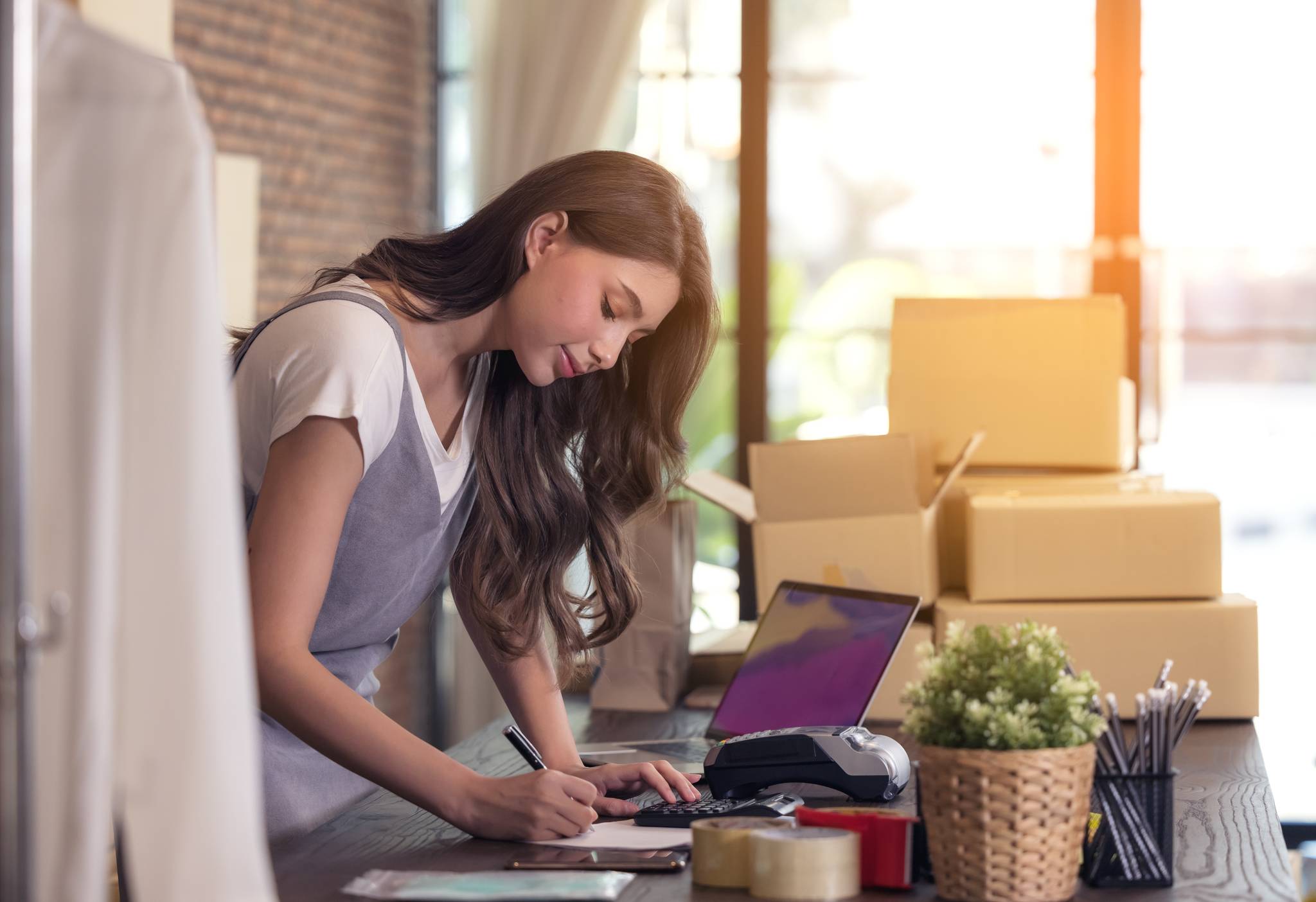 Young woman tailor with laptop is answering emails business woman