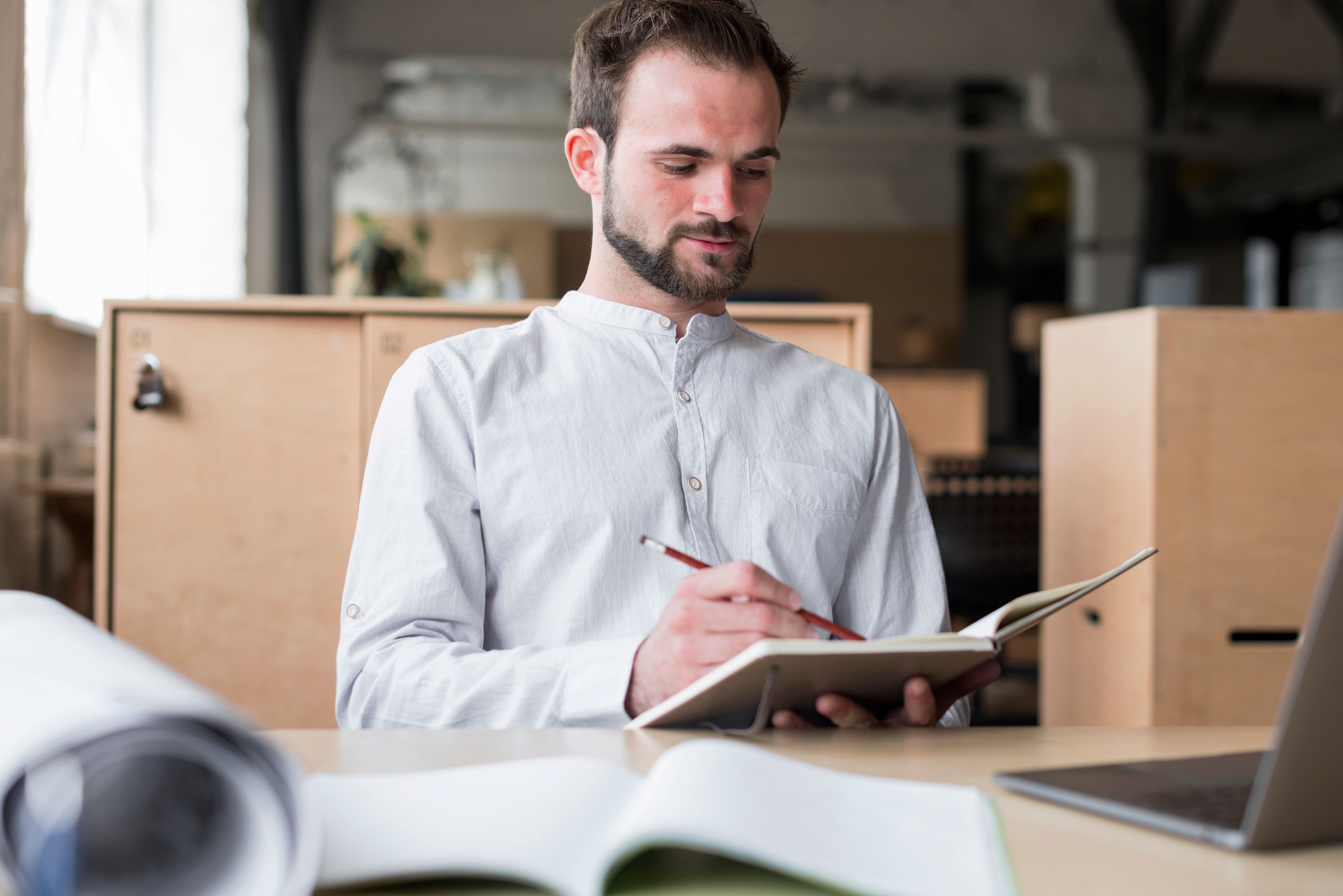 young man with notepad with boxes behind