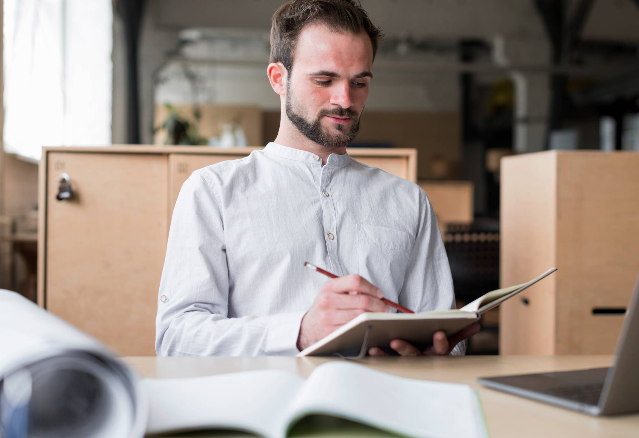 young man with notepad with boxes behind