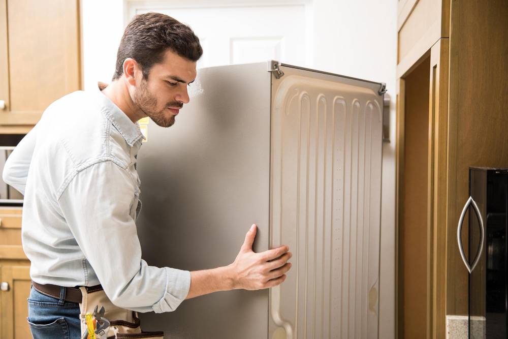 young man moving refrigerator