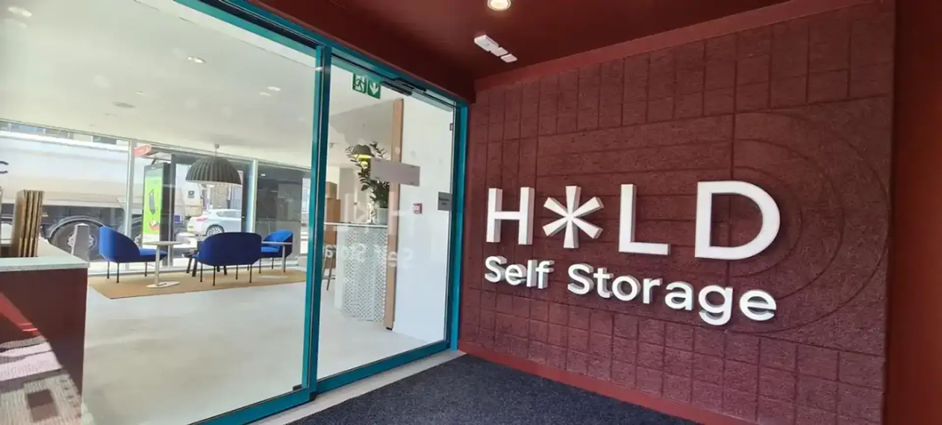 An office with the HOLD Self Storage logo on the wall