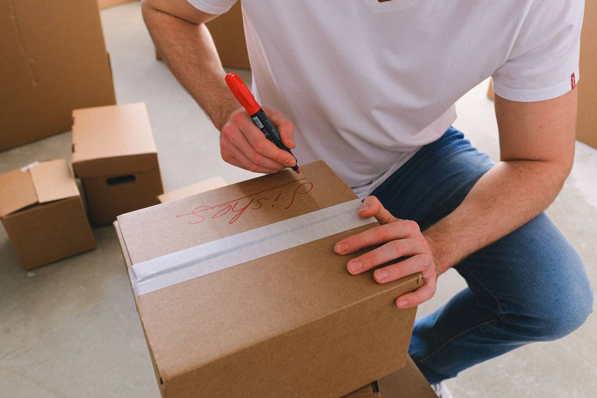 man labelling a wrapped cardboard box for short term storage