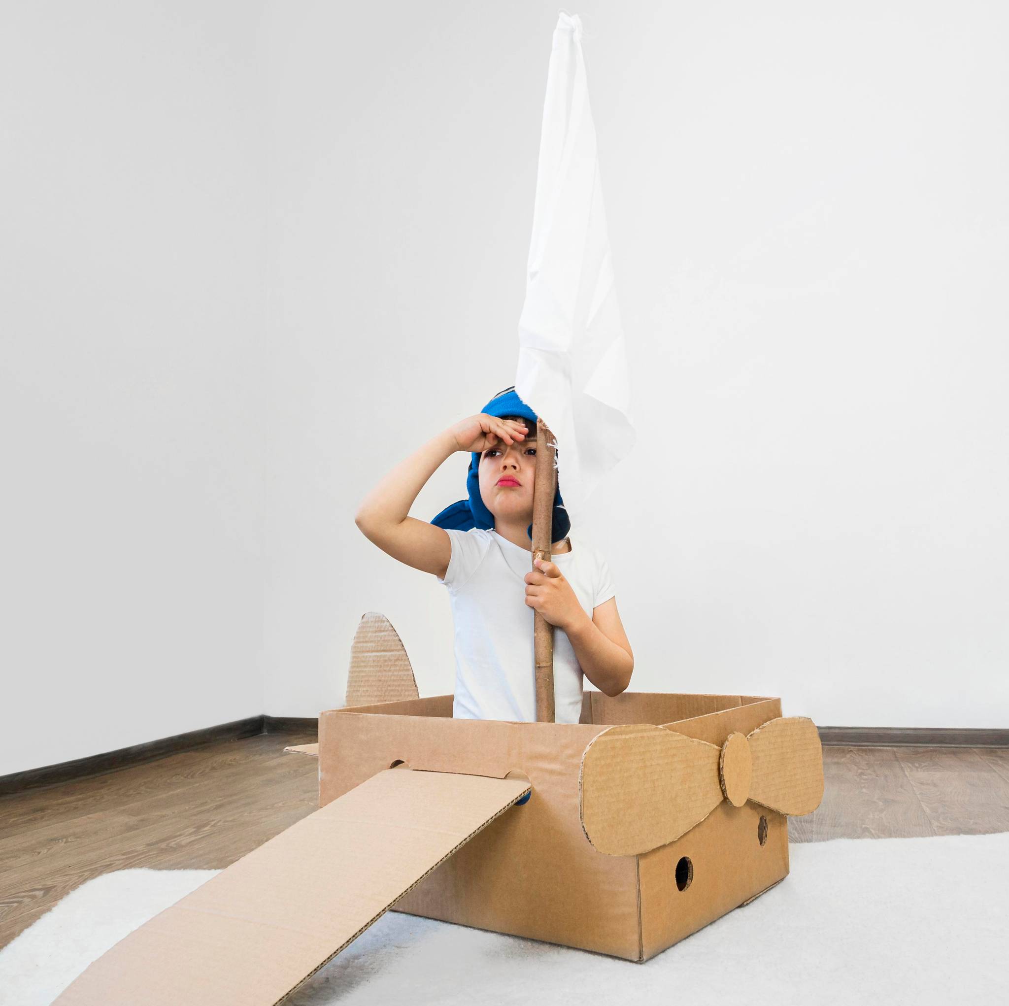 Kid playing with cardboard boat