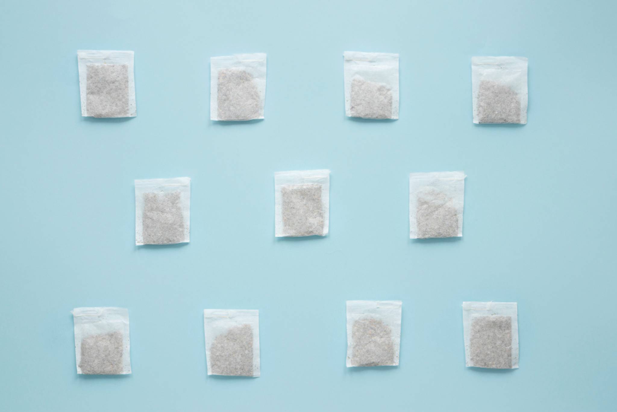 Multiple silica gel packs lined up in rows on a blue table