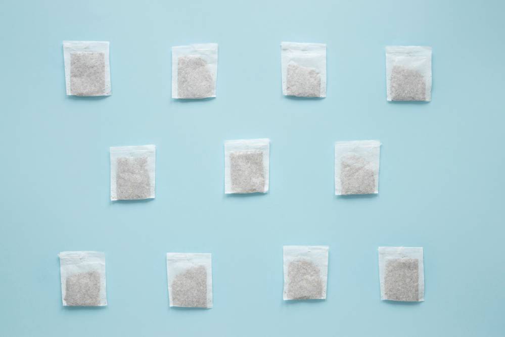 Multiple silica gel packs lined up in rows on a blue table