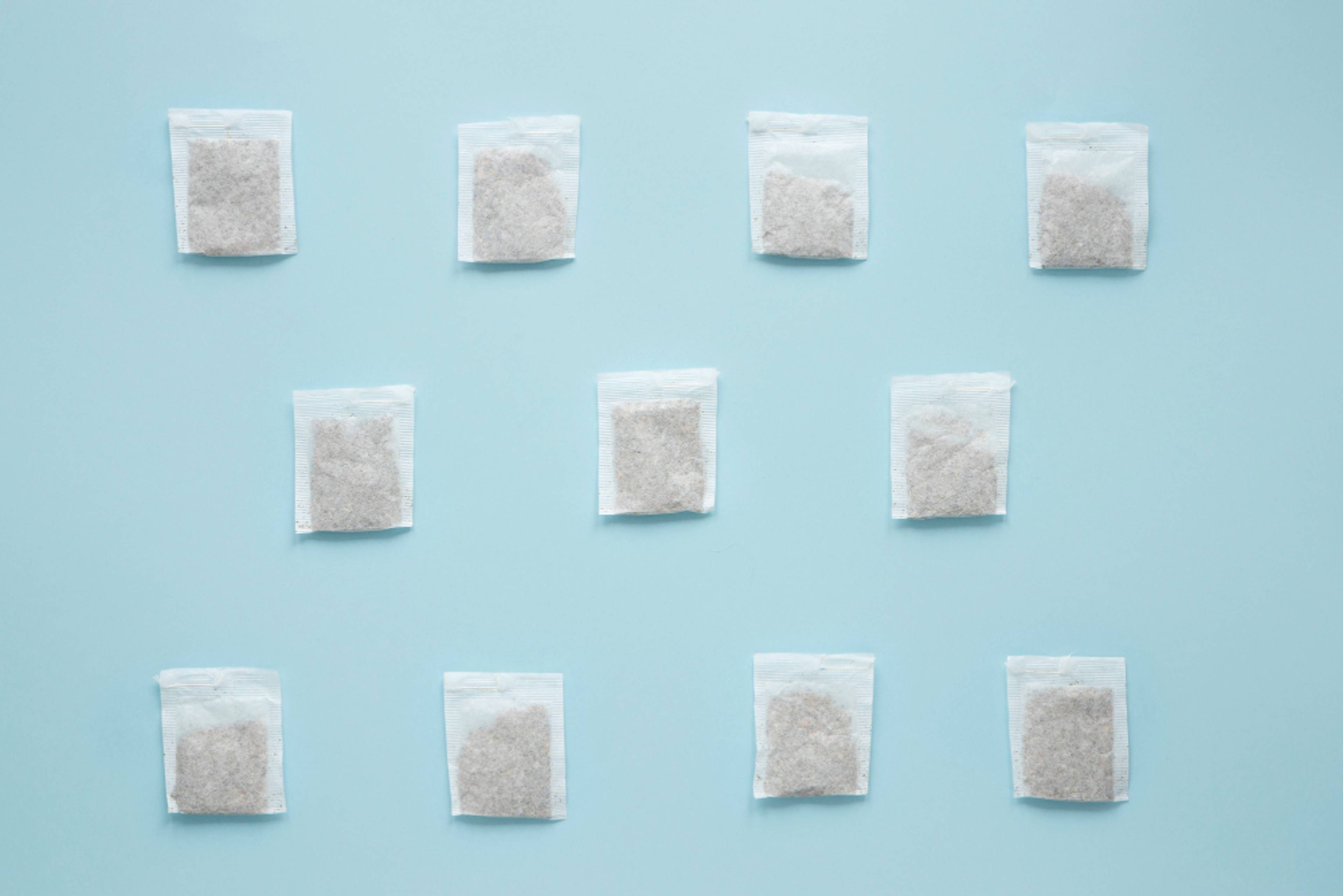 Multiple silica gel packs lined up in rows on a blue table