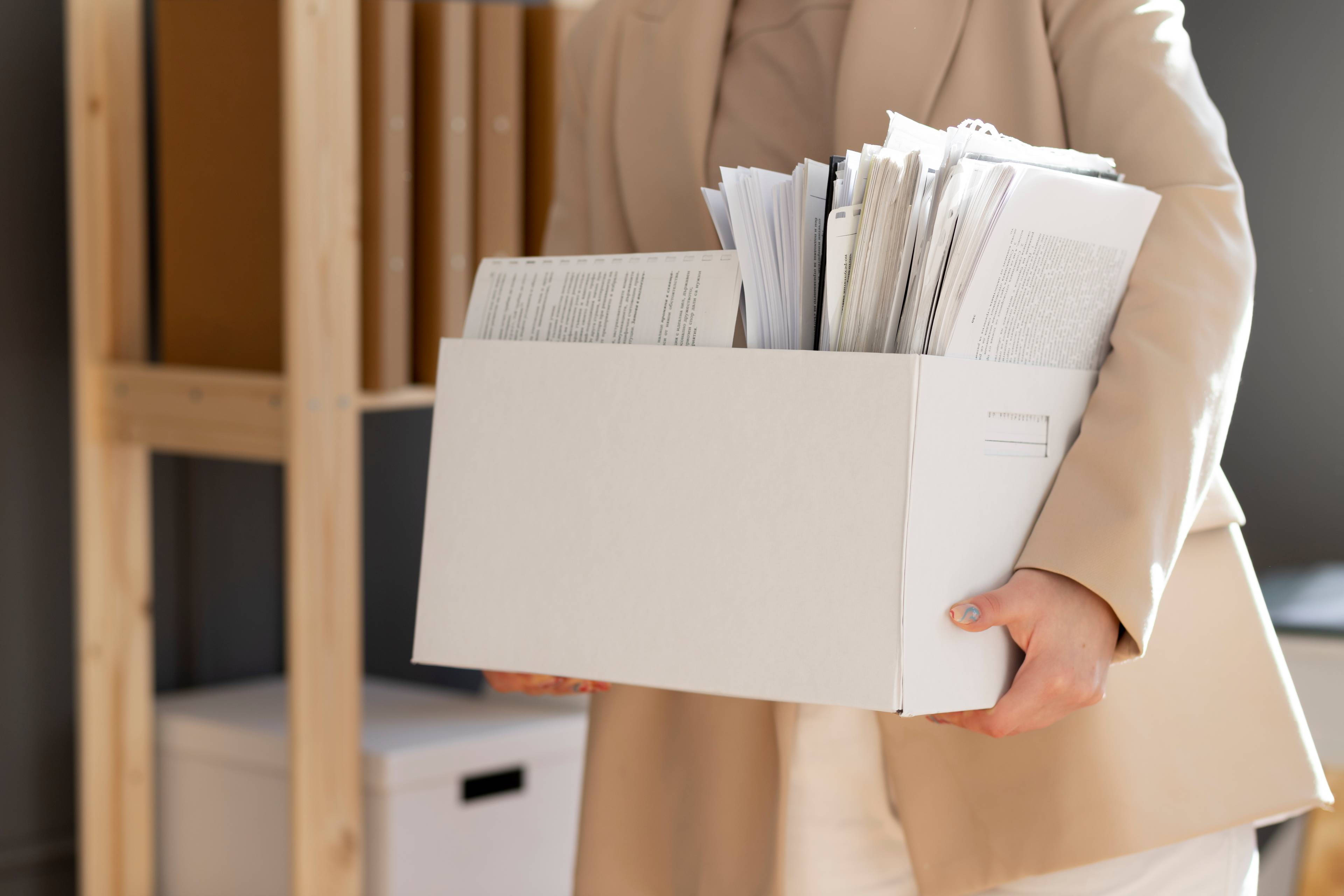 Young adult organizing a box of files.