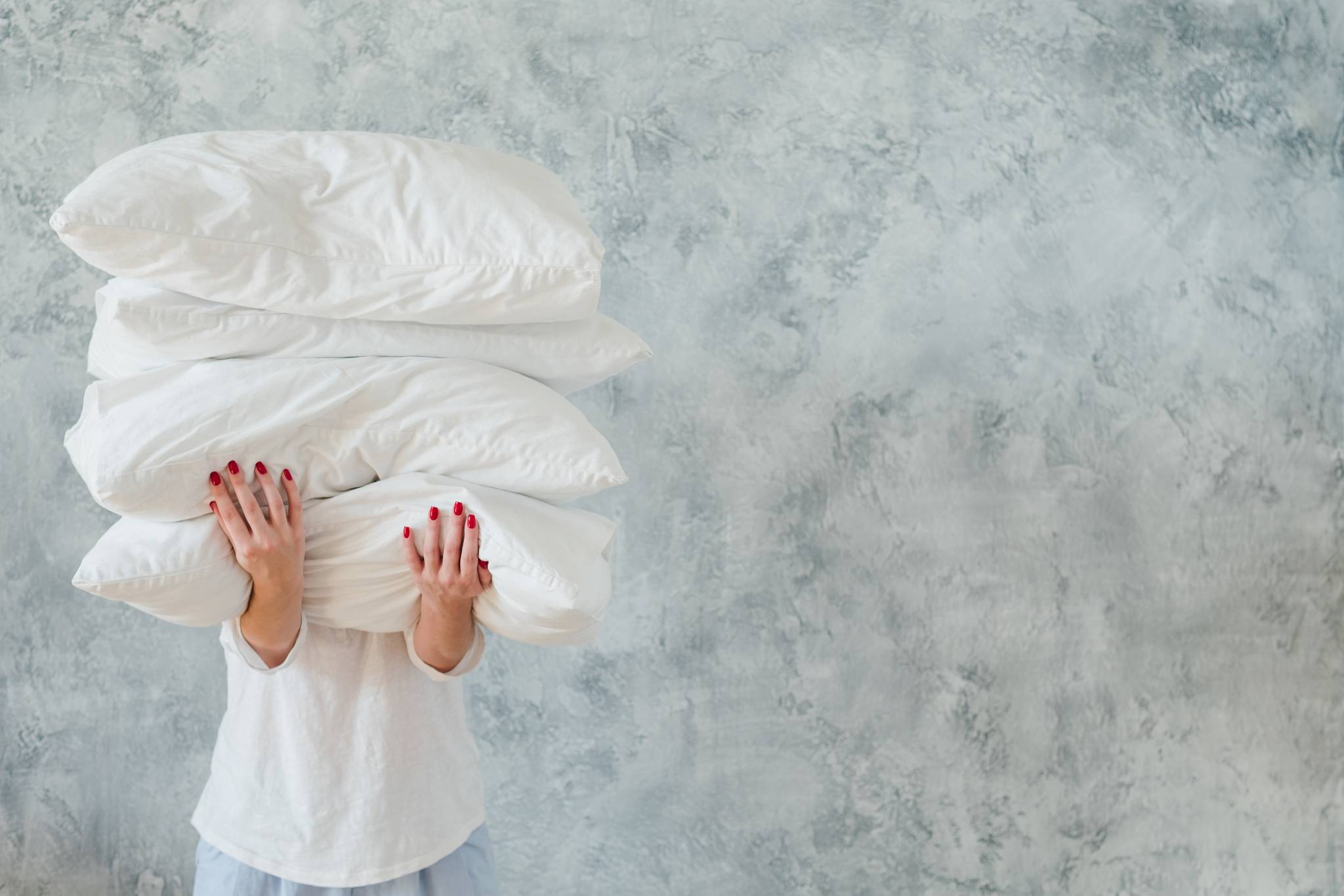 A woman carrying stack of pillows