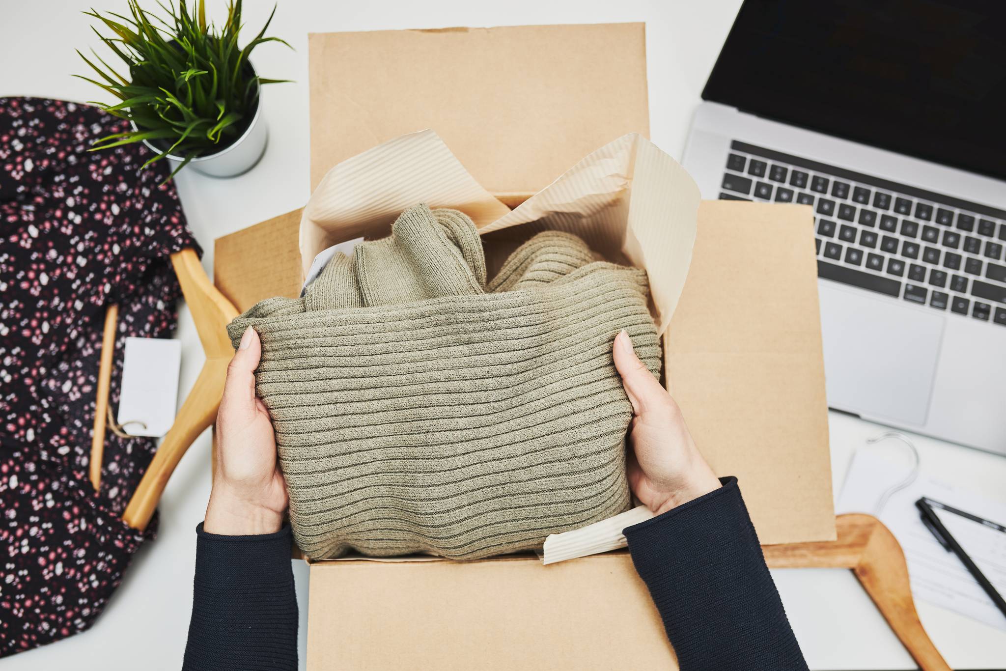 Woman packing away coats in a box