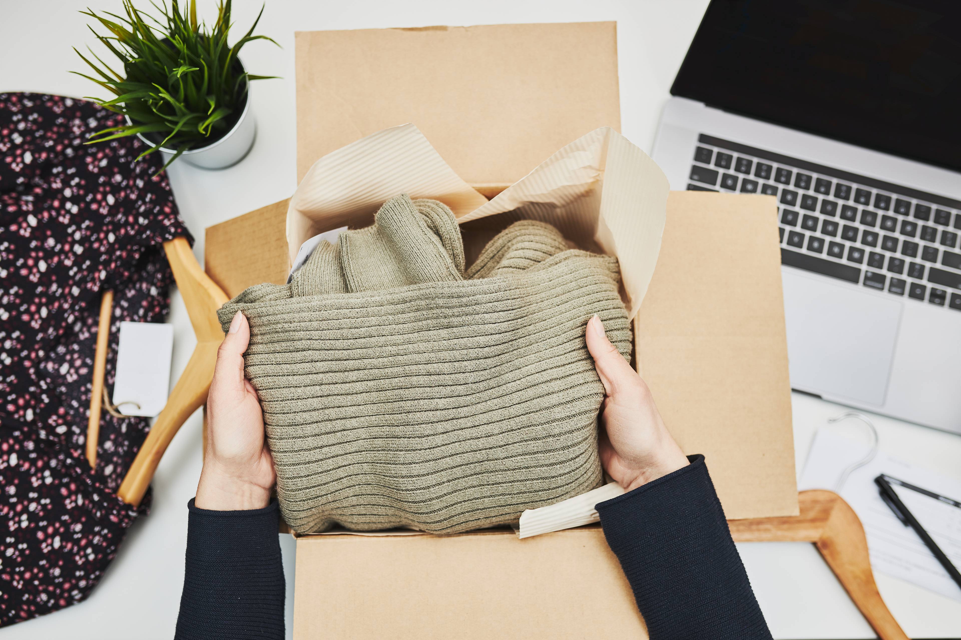 Woman packing away coats in a box