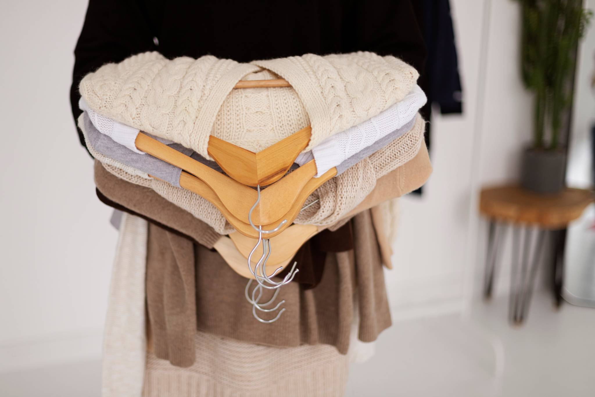 Close up of hand holding hangers with coats