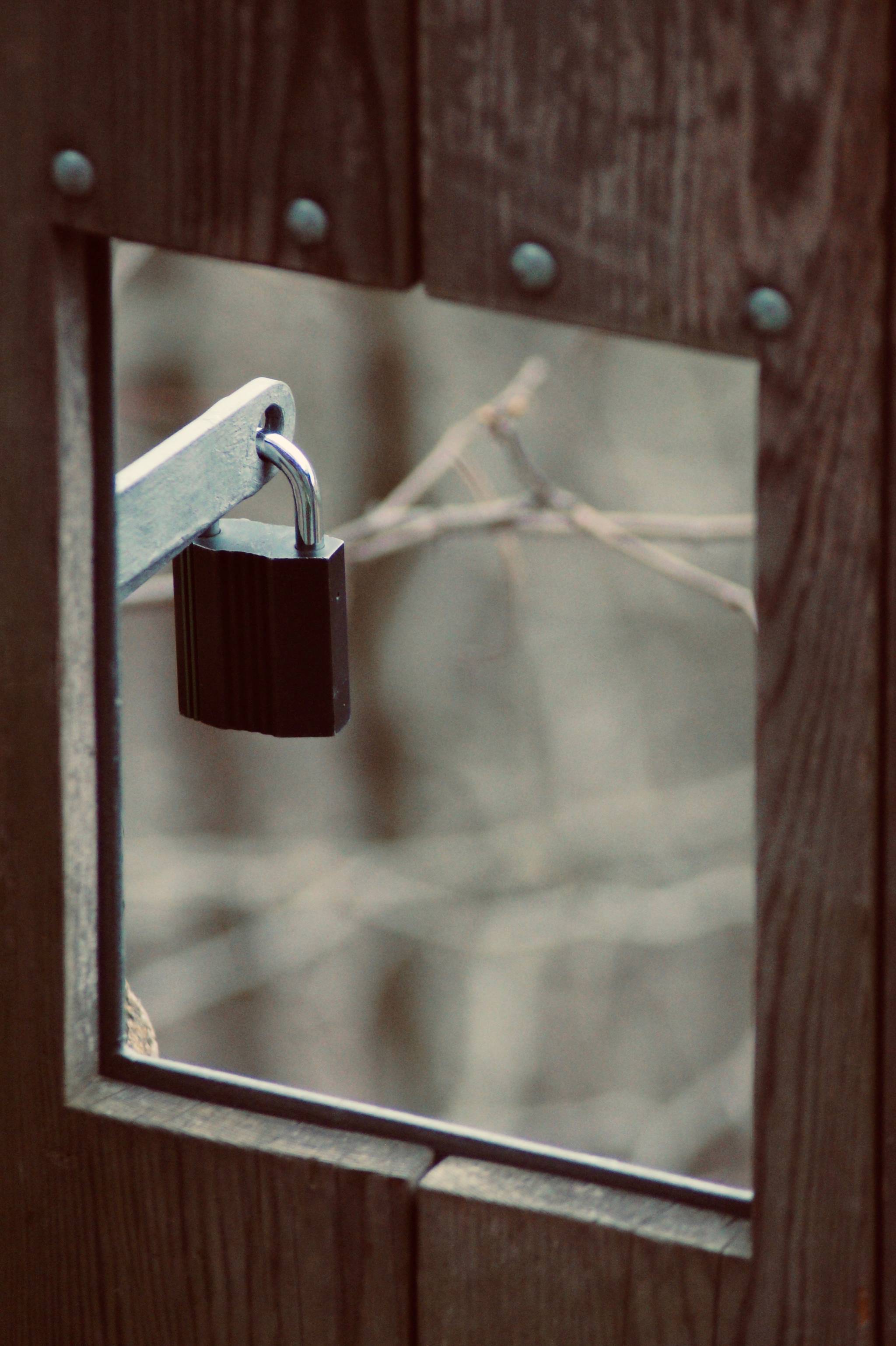 Padlock hanging as seen through a window.
