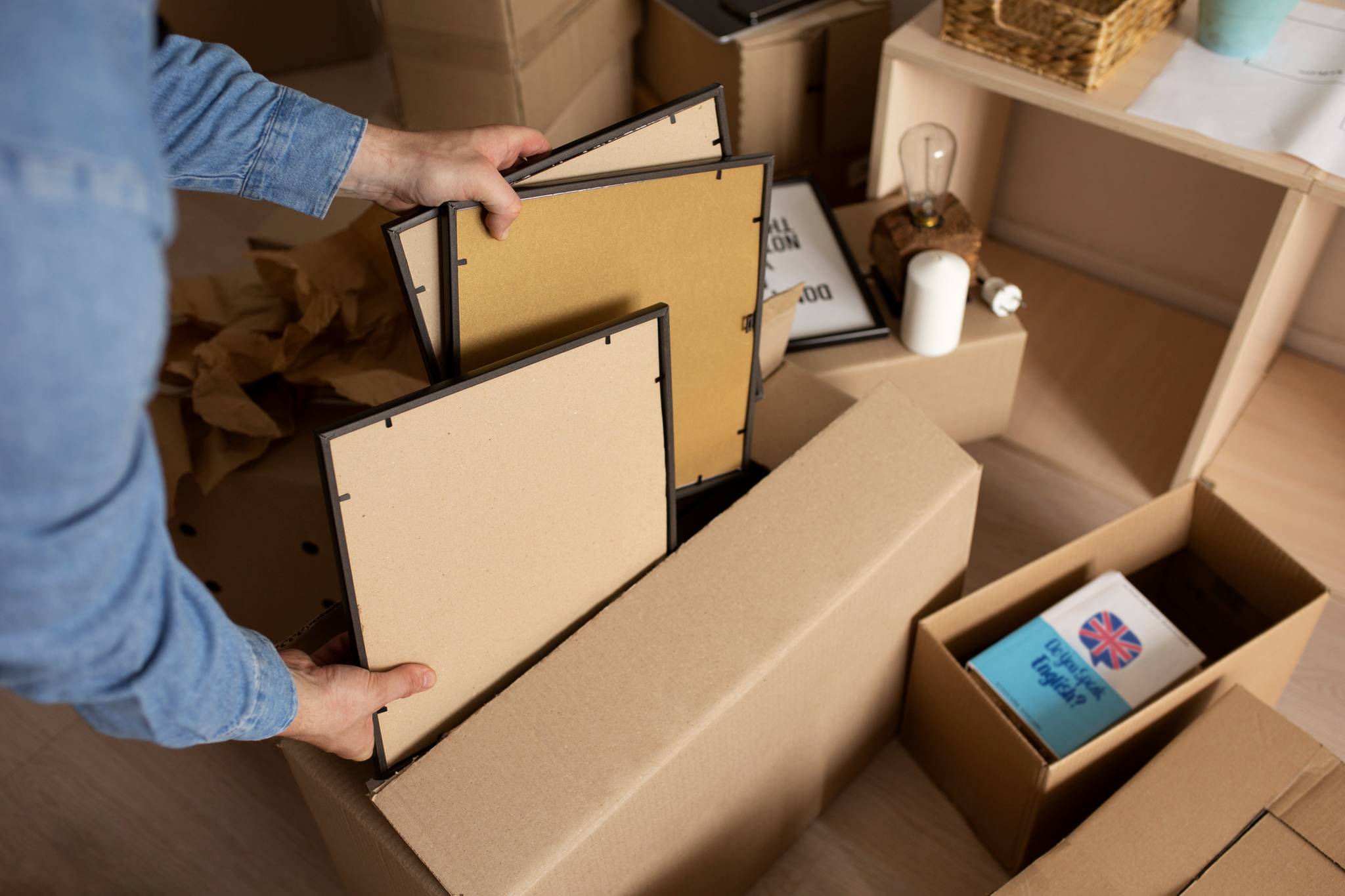 Man putting away some frames into a cardboard box