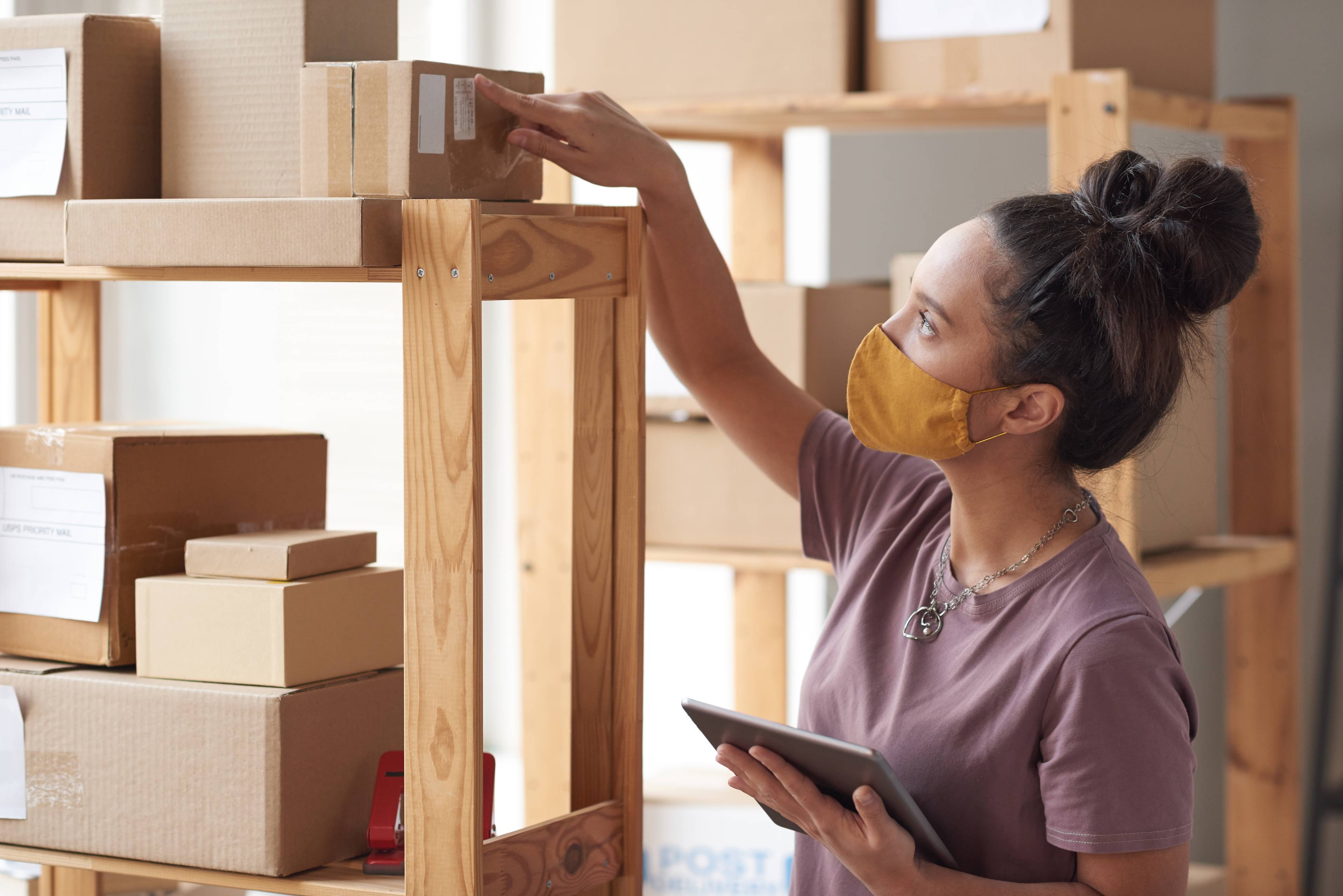 Young woman checking boxes in storage