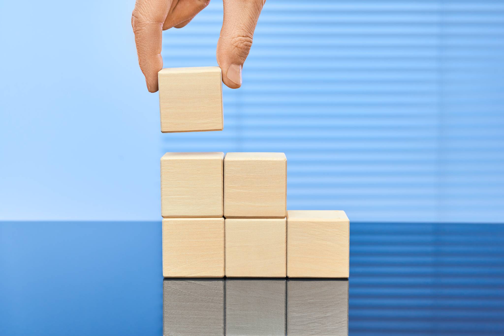 Hand placing wooden blocks