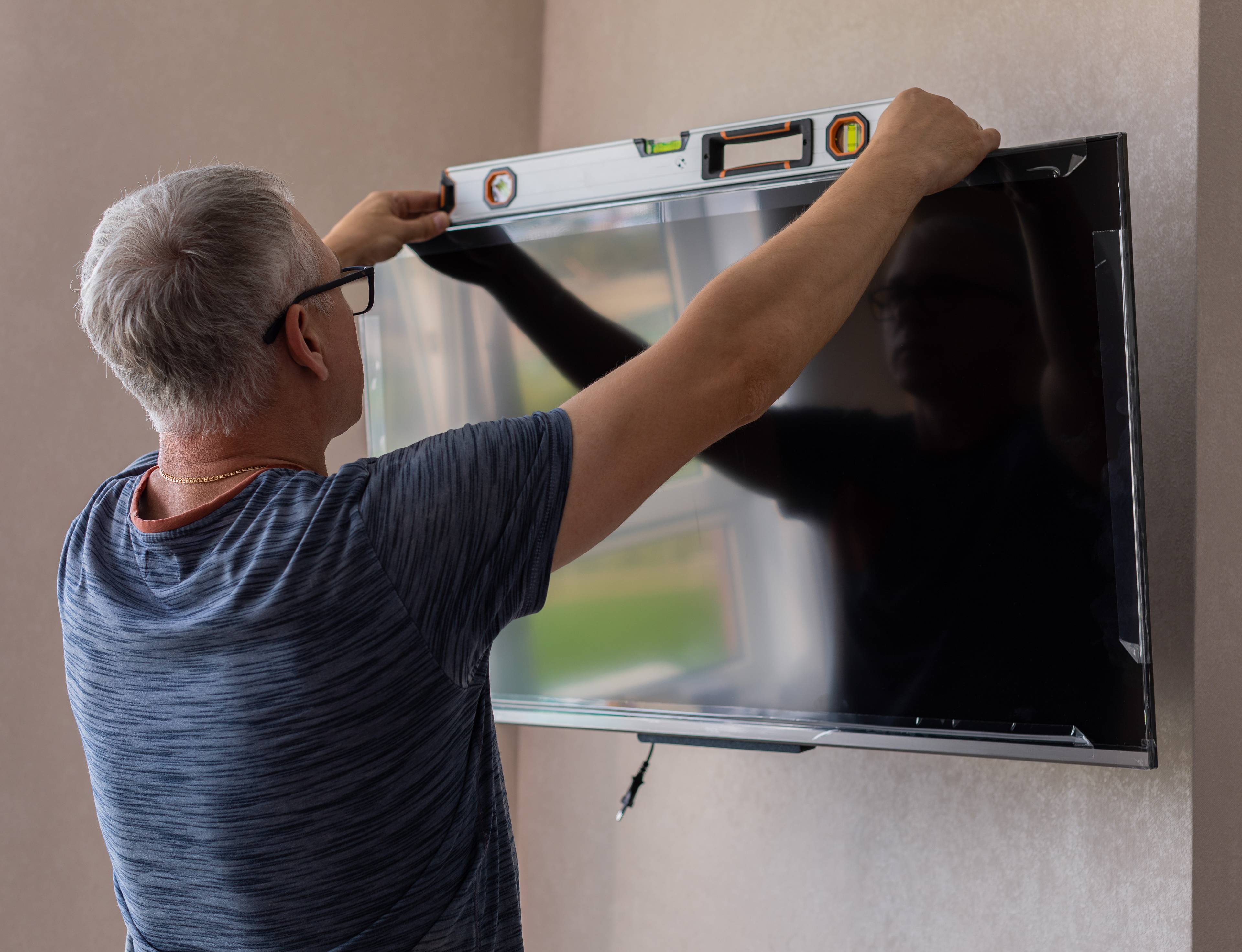 man measuring tv with spirit meter