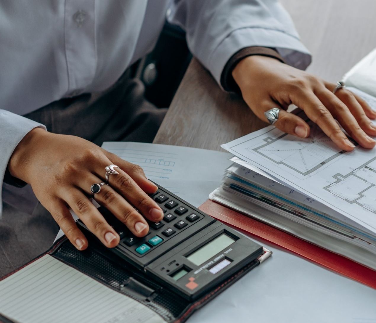 office worker auditing assets with calculator and files