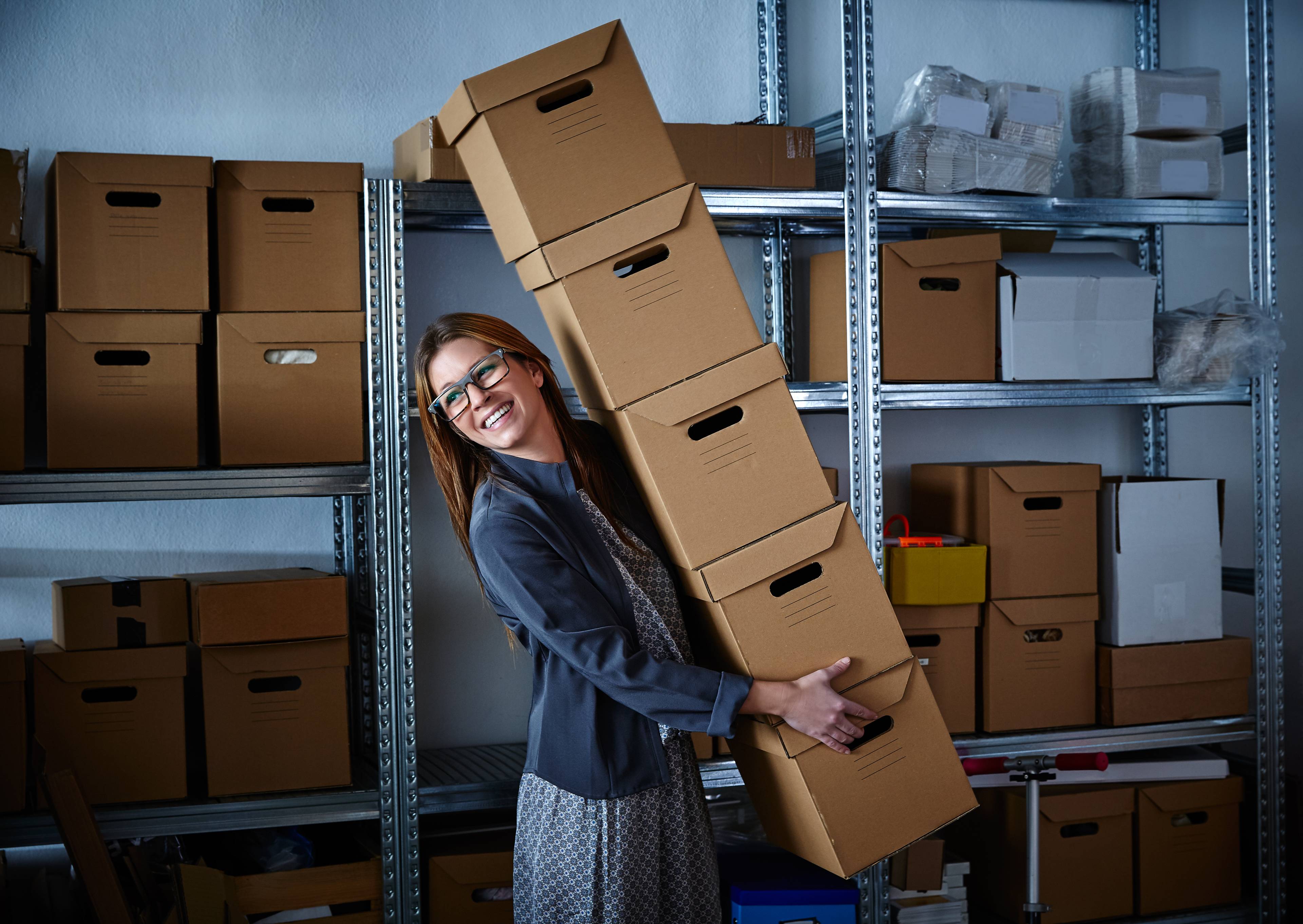 funny business owner carrying tower of cardbaord boxes