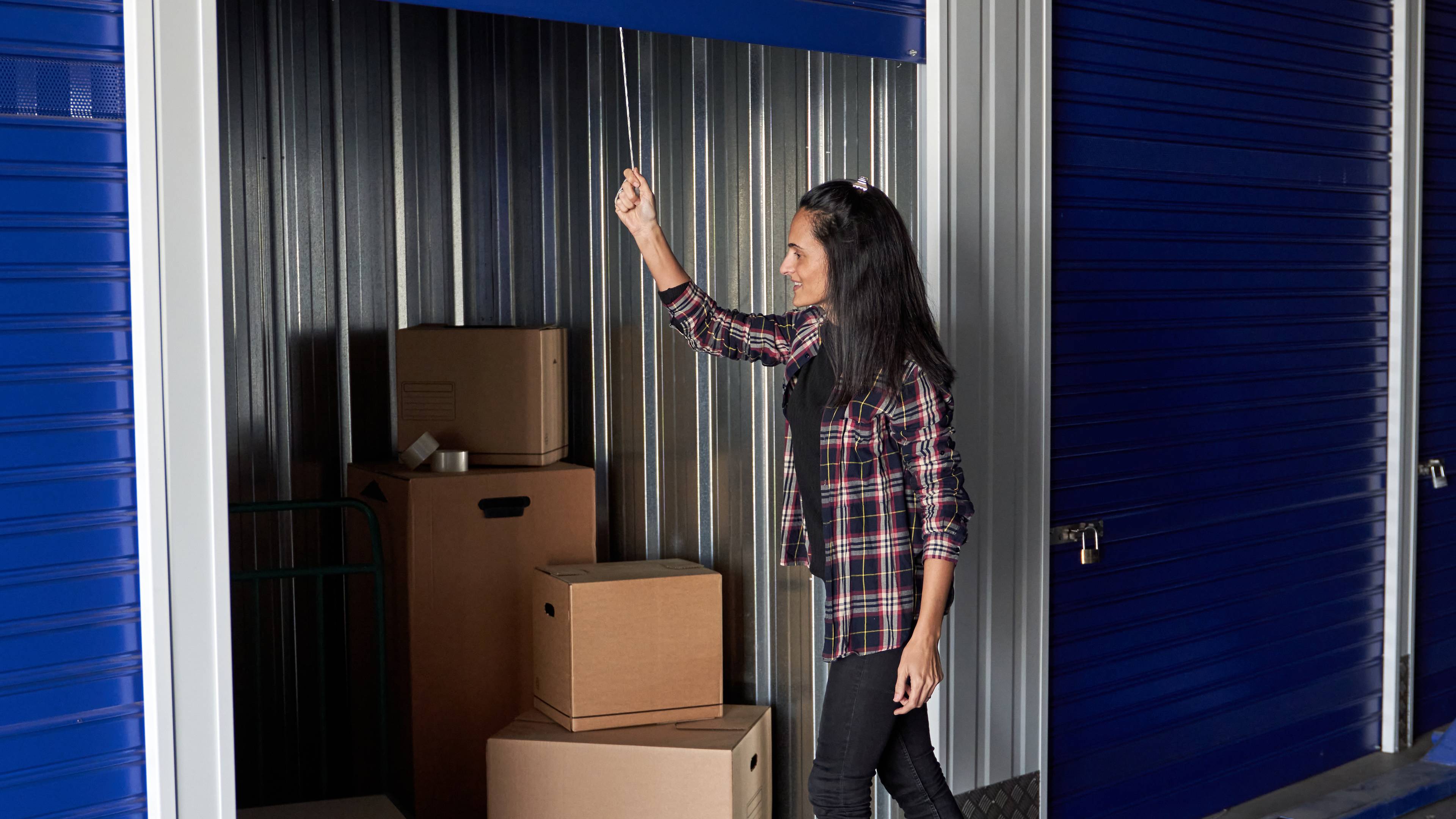 Woman closing door to her self storage unit