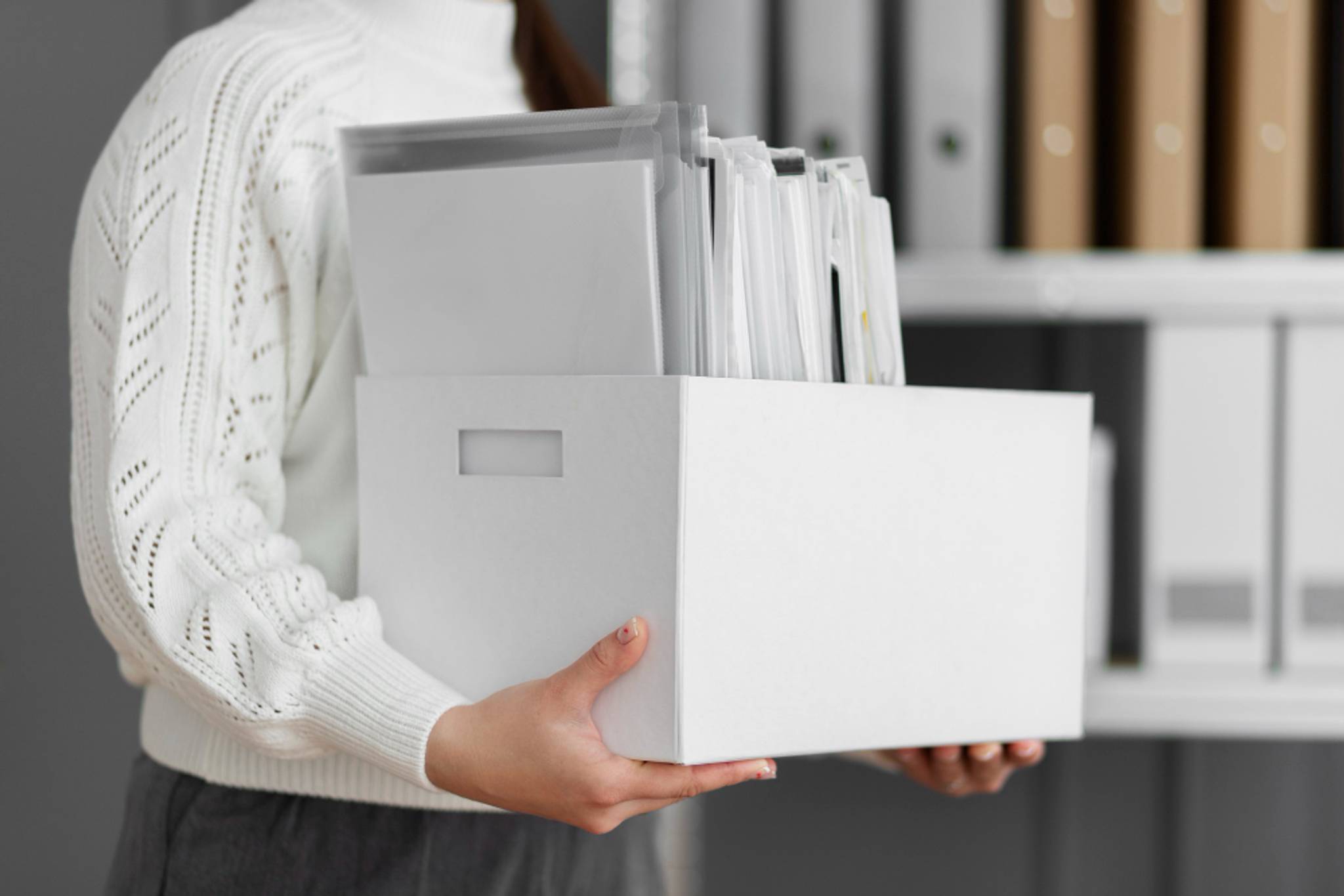 person holding box of files 