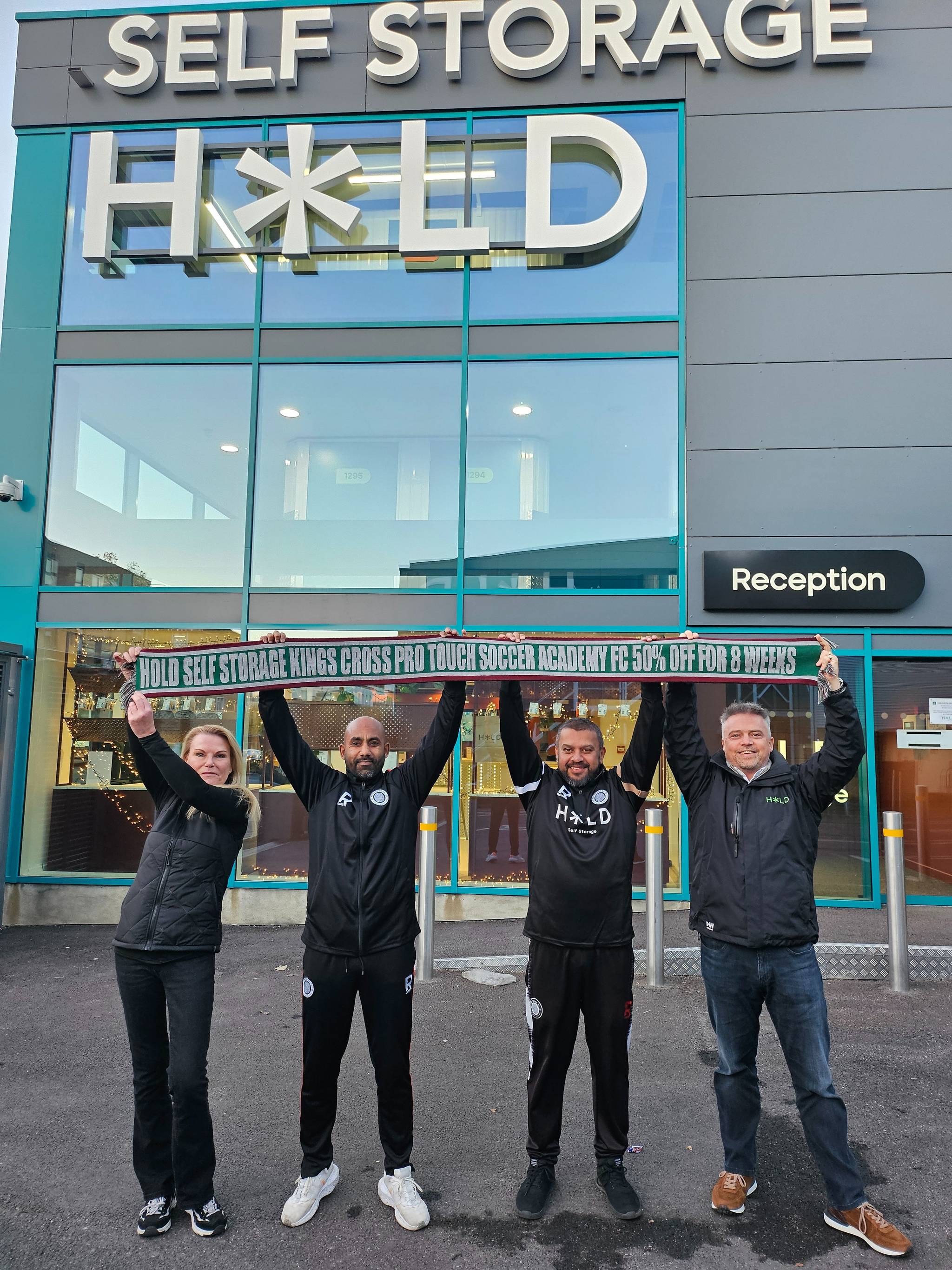 people holding up banner outside hold self storage facility in london