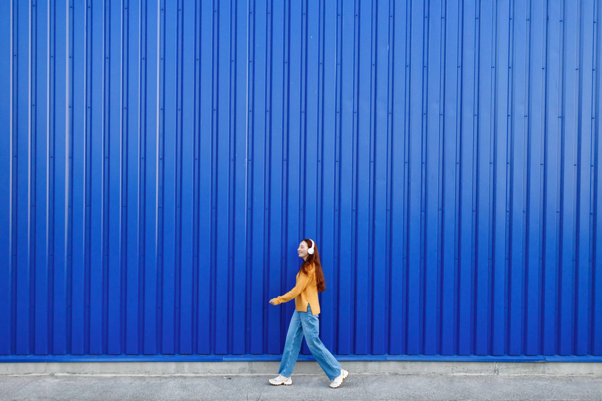 Red haired woman walking in front of container storage.
