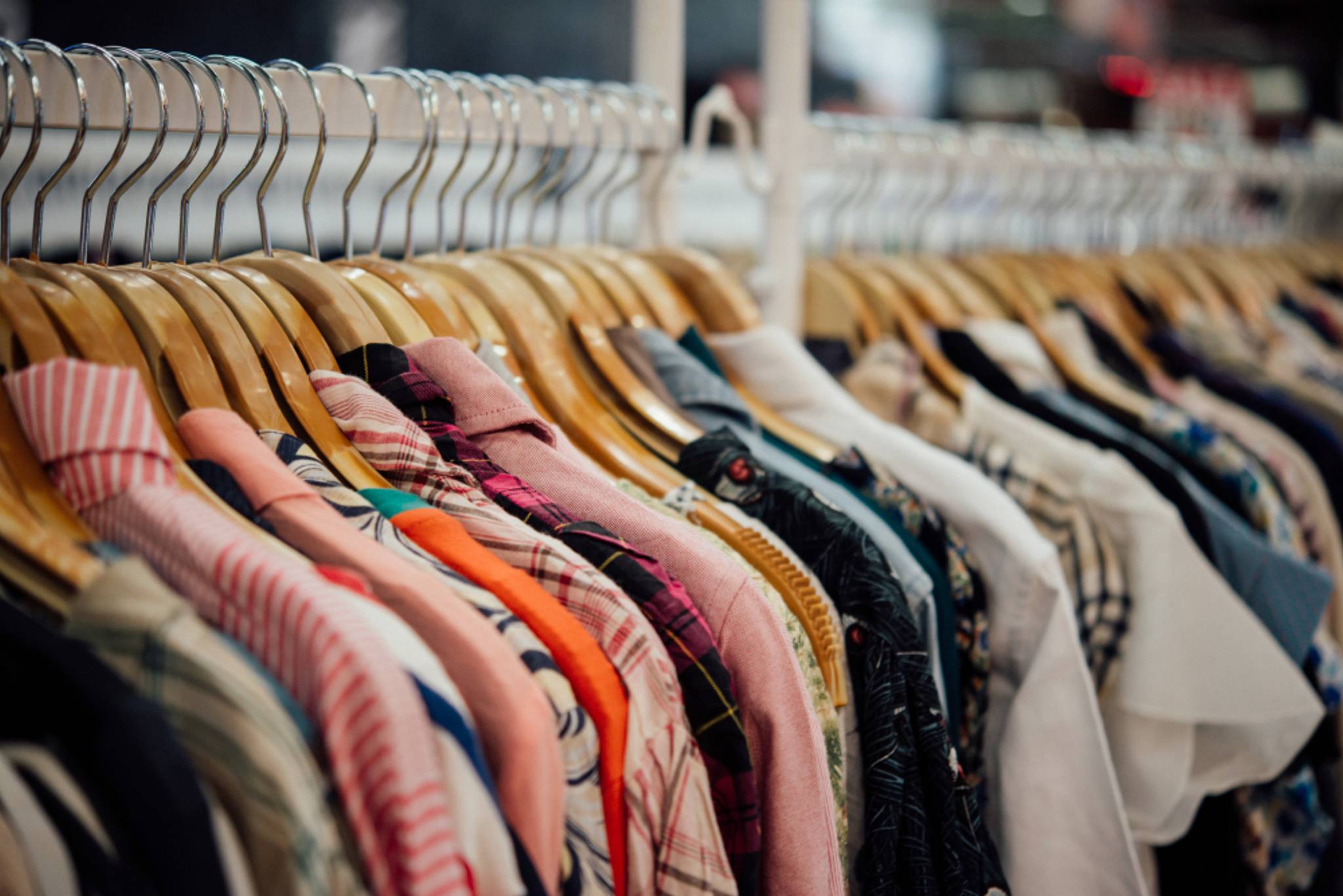 A long row of shirts are hung up on a clothing rack