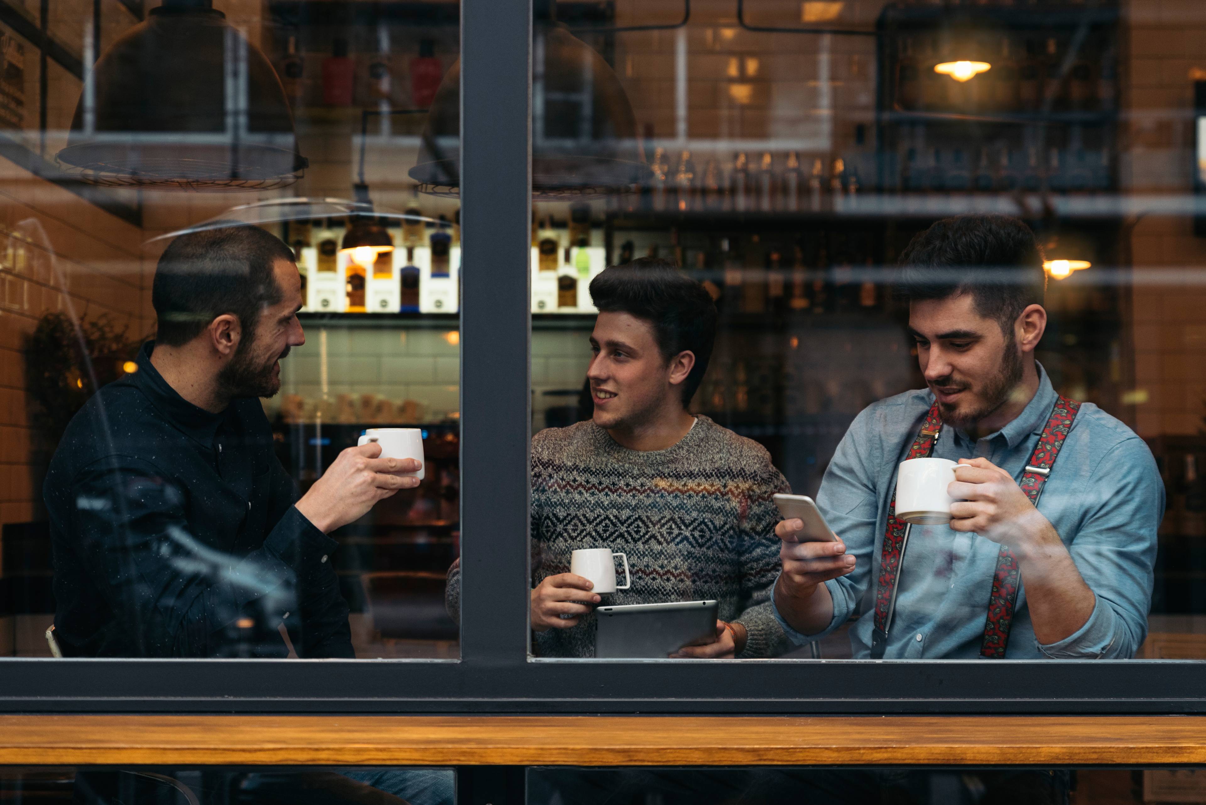 Friends drinking coffee and chatting in cafe.