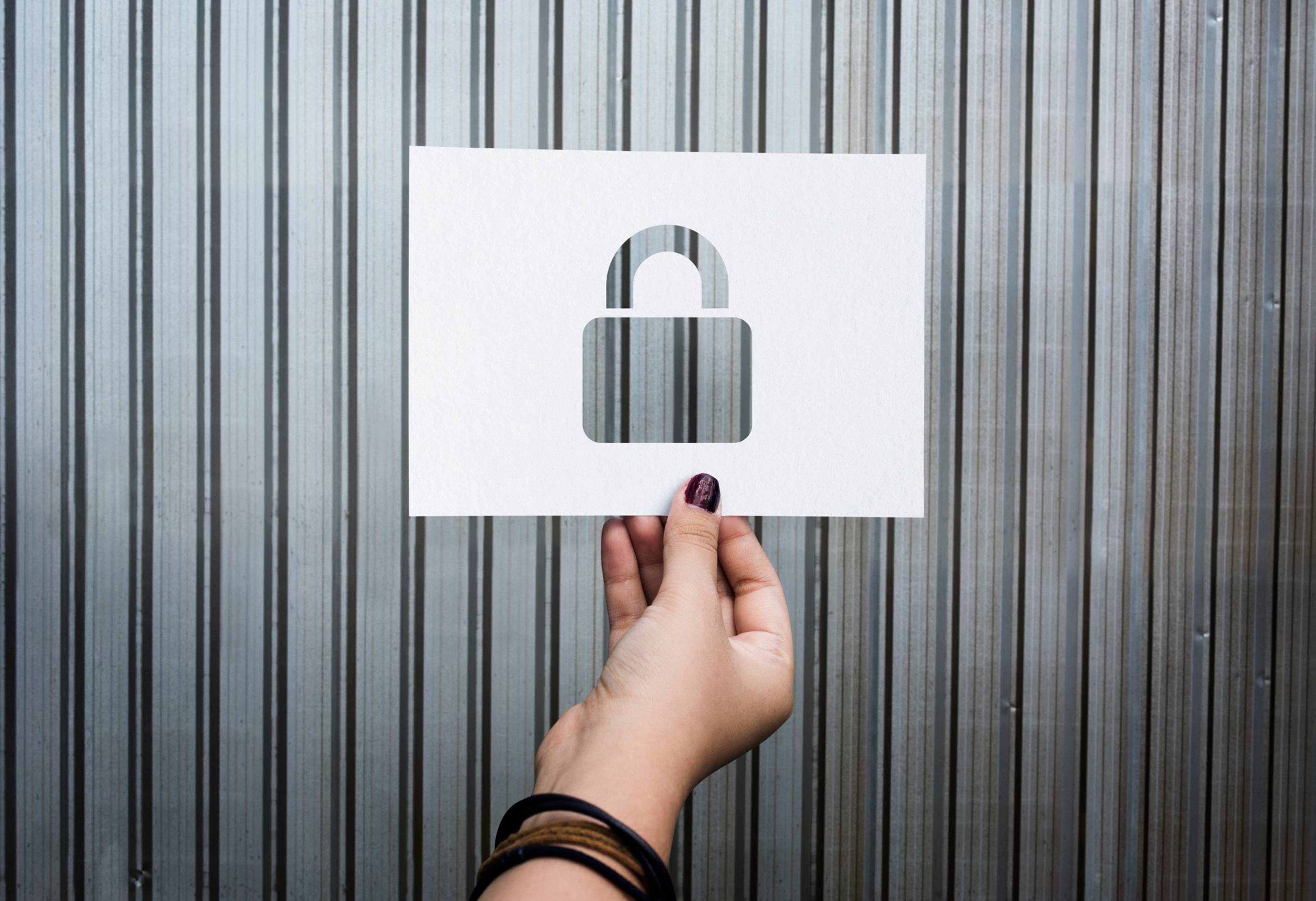 A woman holding out a stencil with a lock cut out
