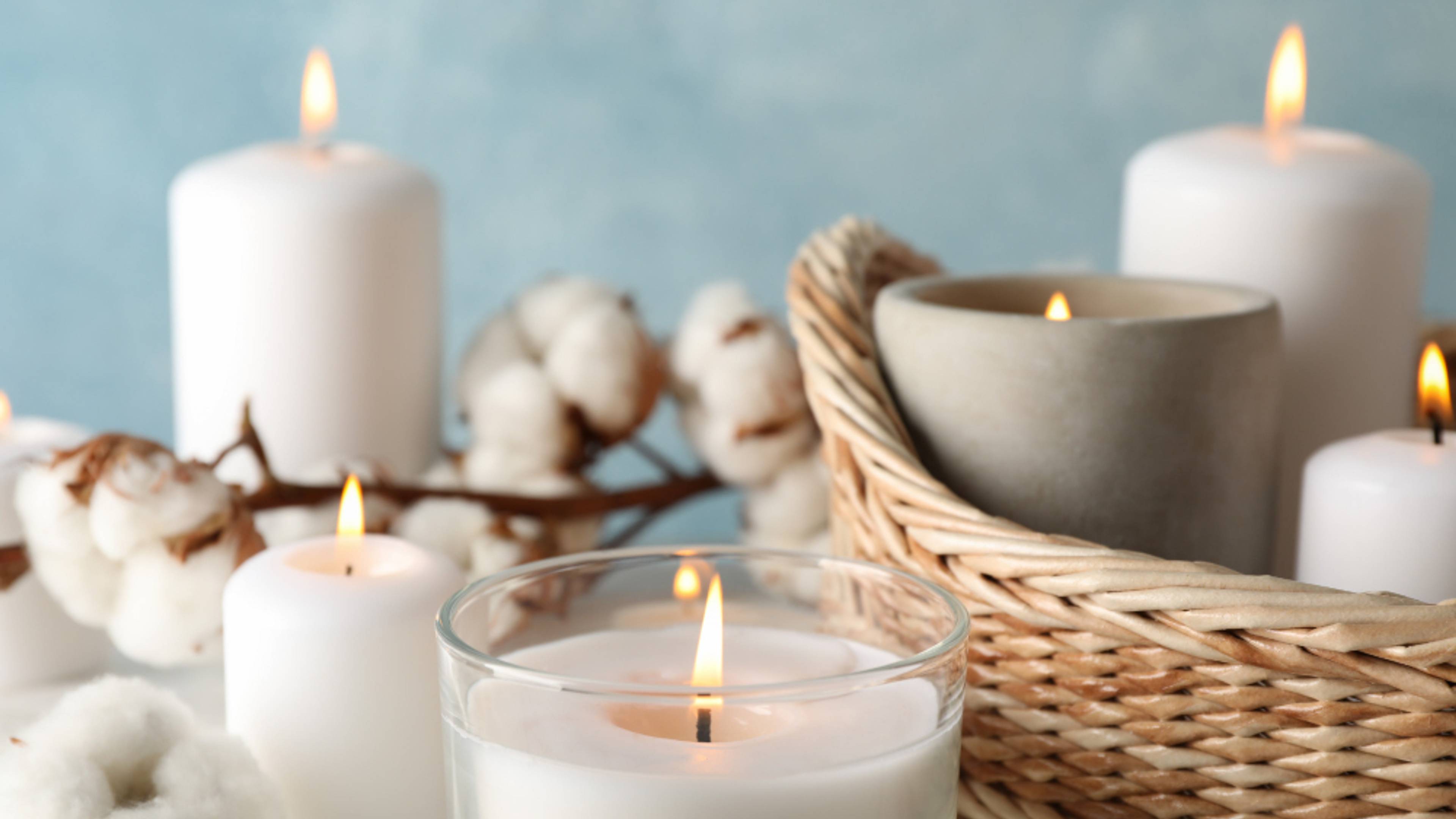 A group of candles, all lit, against a soft blue background