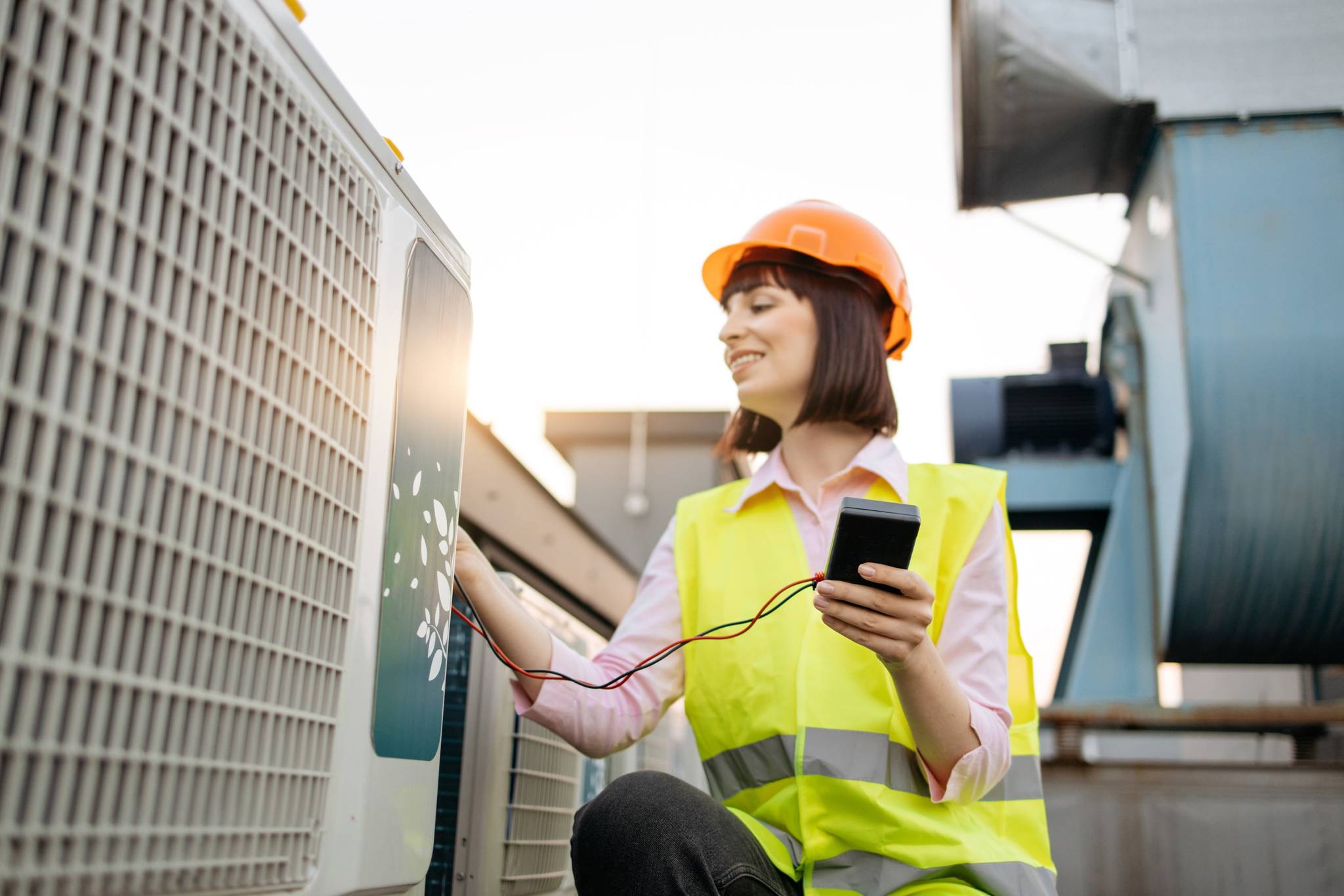 Female staff checking airconditioning unit.